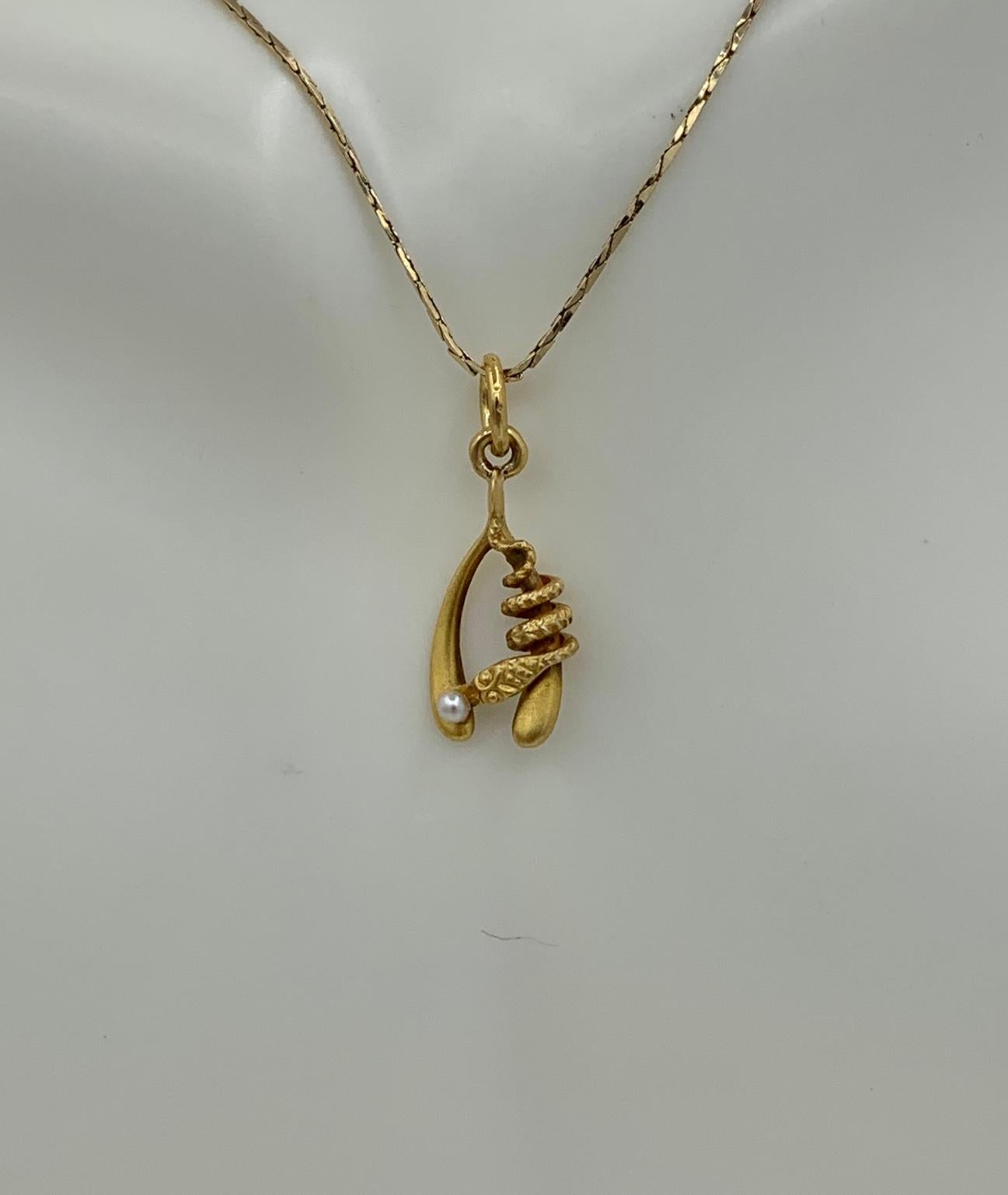 This is a very rare antique Victorian Snake Pendant Necklace depicting a snake or serpent wrapped around a Wishbone with a natural Pearl egg or globe.  The snake is beautifully created with stunning three dimensional design in 10 Karat yellow gold. 
