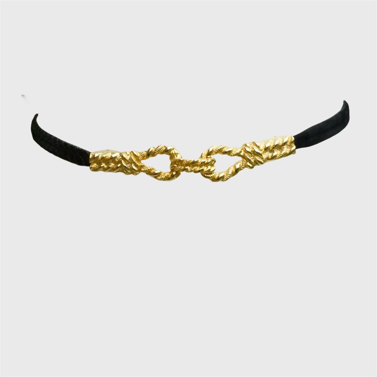 Cintura in pelle di serpente e camoscio, con una splendida fibbia dorata dal design a spirale. La cintura è per metà in pelle di serpente e per metà in pelle scamosciata. È in ottime condizioni.

Misura 75 cm di lunghezza per 1,5 cm di larghezza.

È