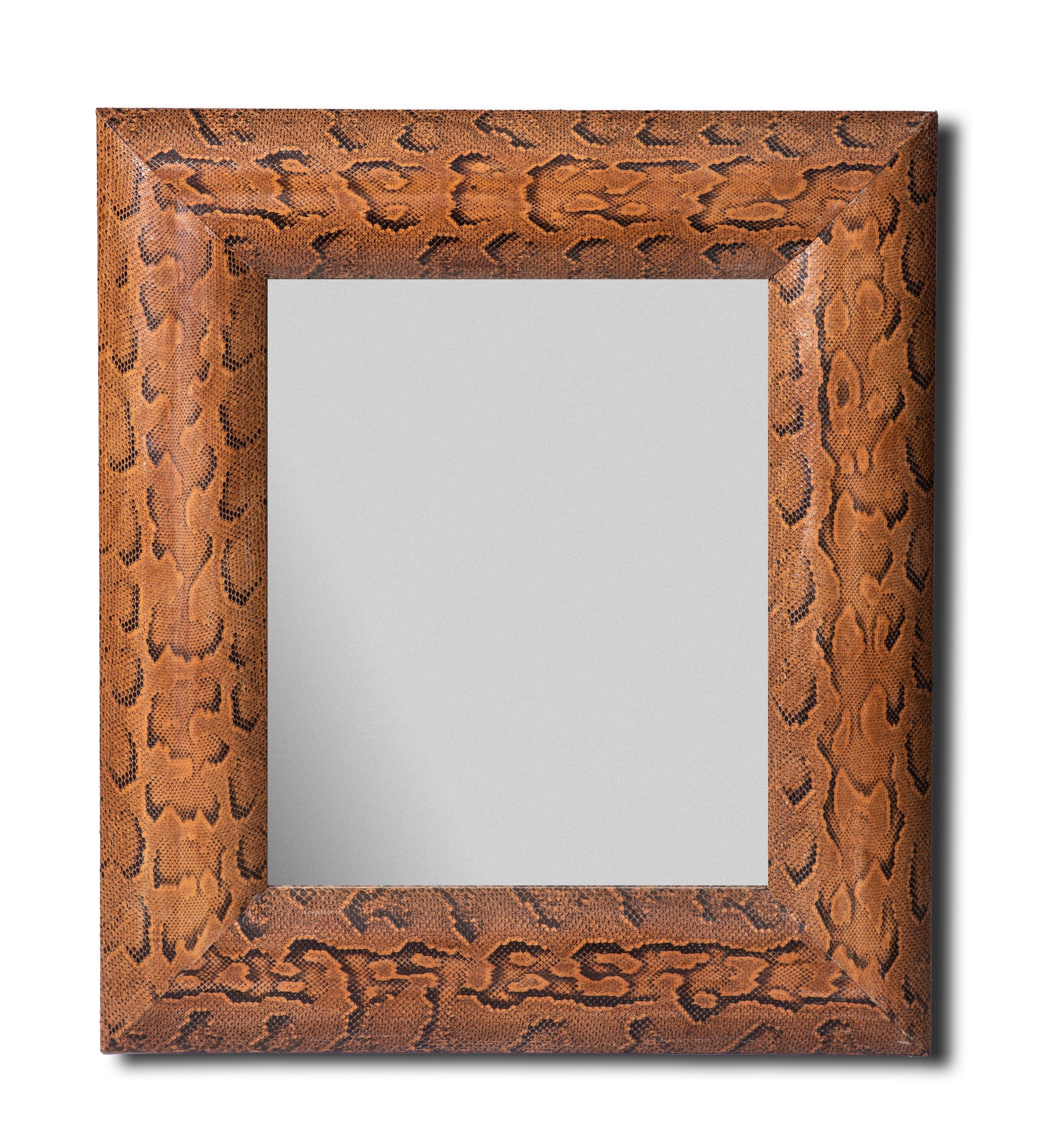 Specchio incorniciato in pelle di pitone su un'anima di legno.
