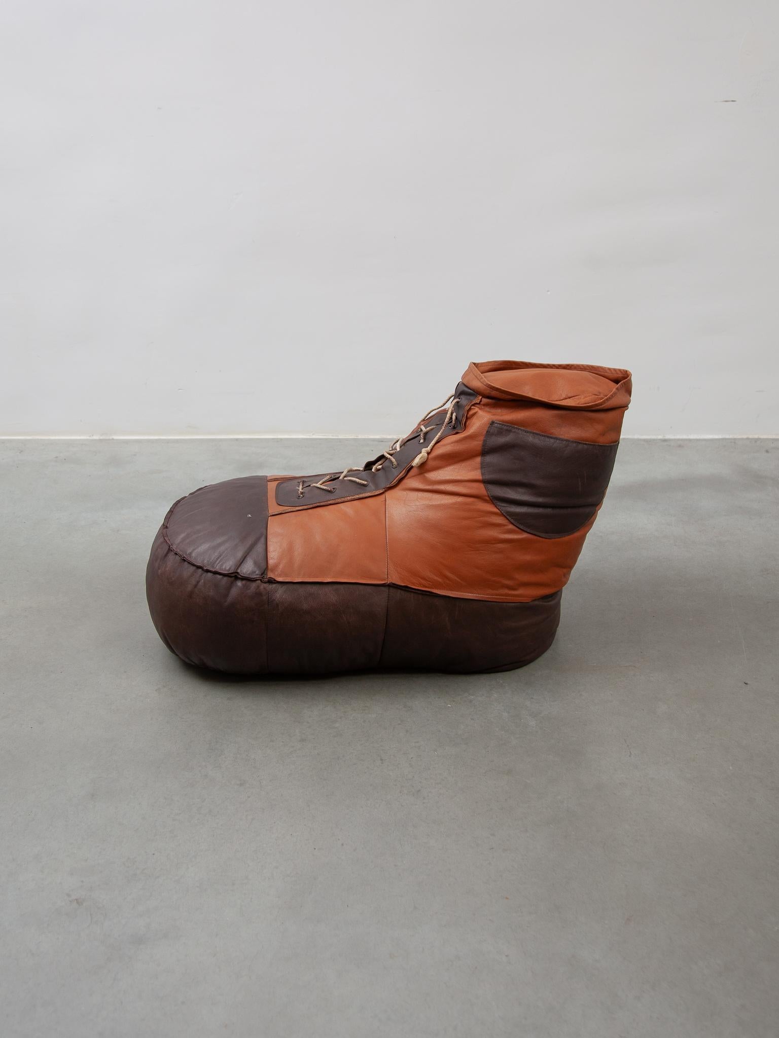 Original ottoman vintage édition De Sede des années 1970 et forme une espadrille de taille surdimensionnée. Il est en cuir bicolore, marron clair et chocolat, avec une très belle patine du temps.
Un look rétro-chic qui fait de ce pouf, ottoman, pouf