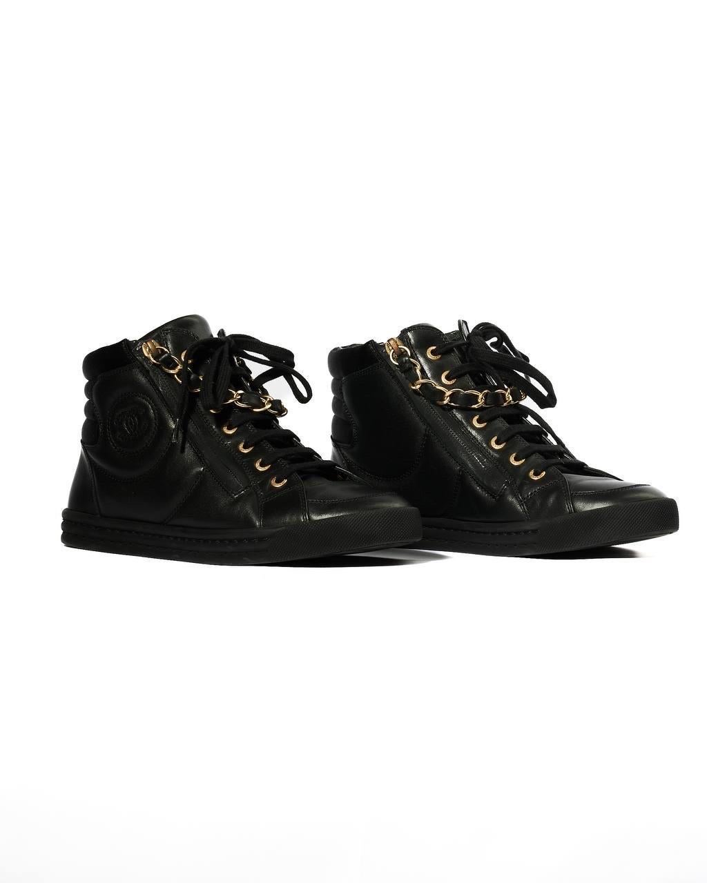 Sneakers firmate Chanel, realizzate in PELLE nera con rifiniture in raso e hardware dorati. Numero 37. Dotato di una  doppia chiusura a zip e lacci, internmnete rivestite in pelle tono su tono. Sul lato presentano il classico logo CC in rilievo. Si