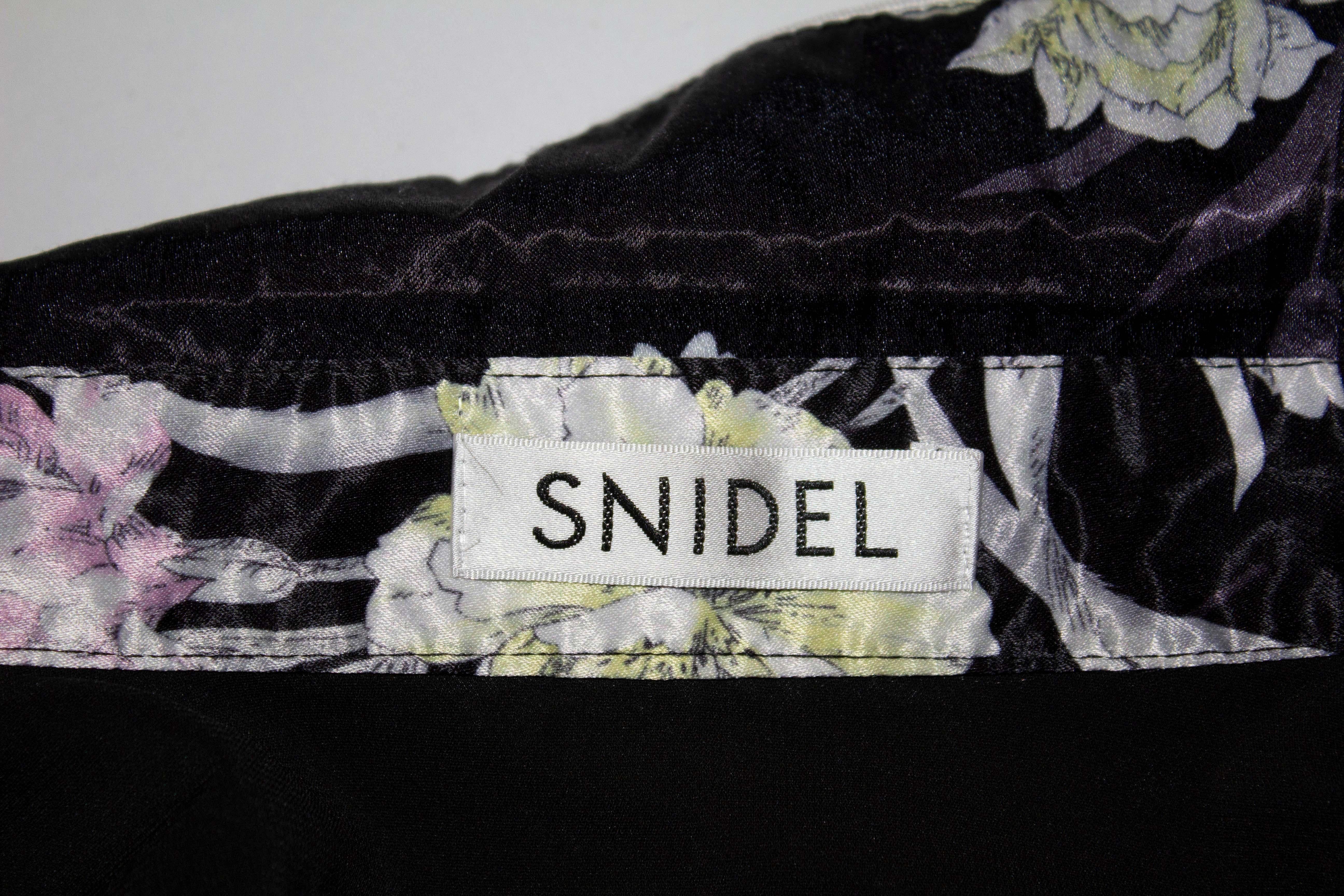 A lovely floral top by Snidel for Mash Style Lab . The top has a print on a black background and white piping. It has a front button opening with a shirt style  hem. Measurements: Bust up to 39'', length 23''