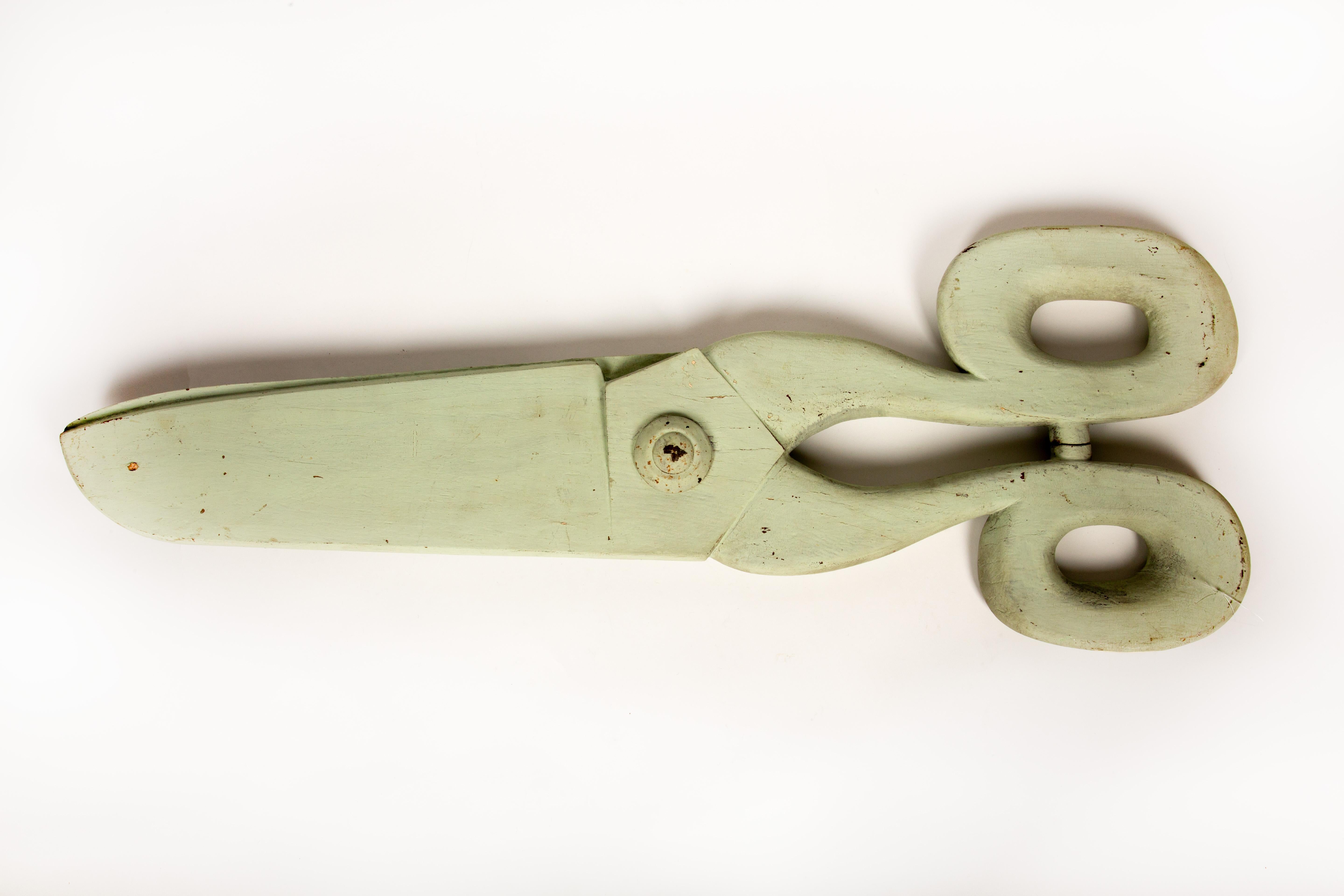 This early 20th-century hand-carved wooden trade sign, shaped like an oversized pair of scissors, is a striking example of French folk art. Measuring an impressive 40 inches in length, it showcases meticulous craftsmanship with smooth curves,