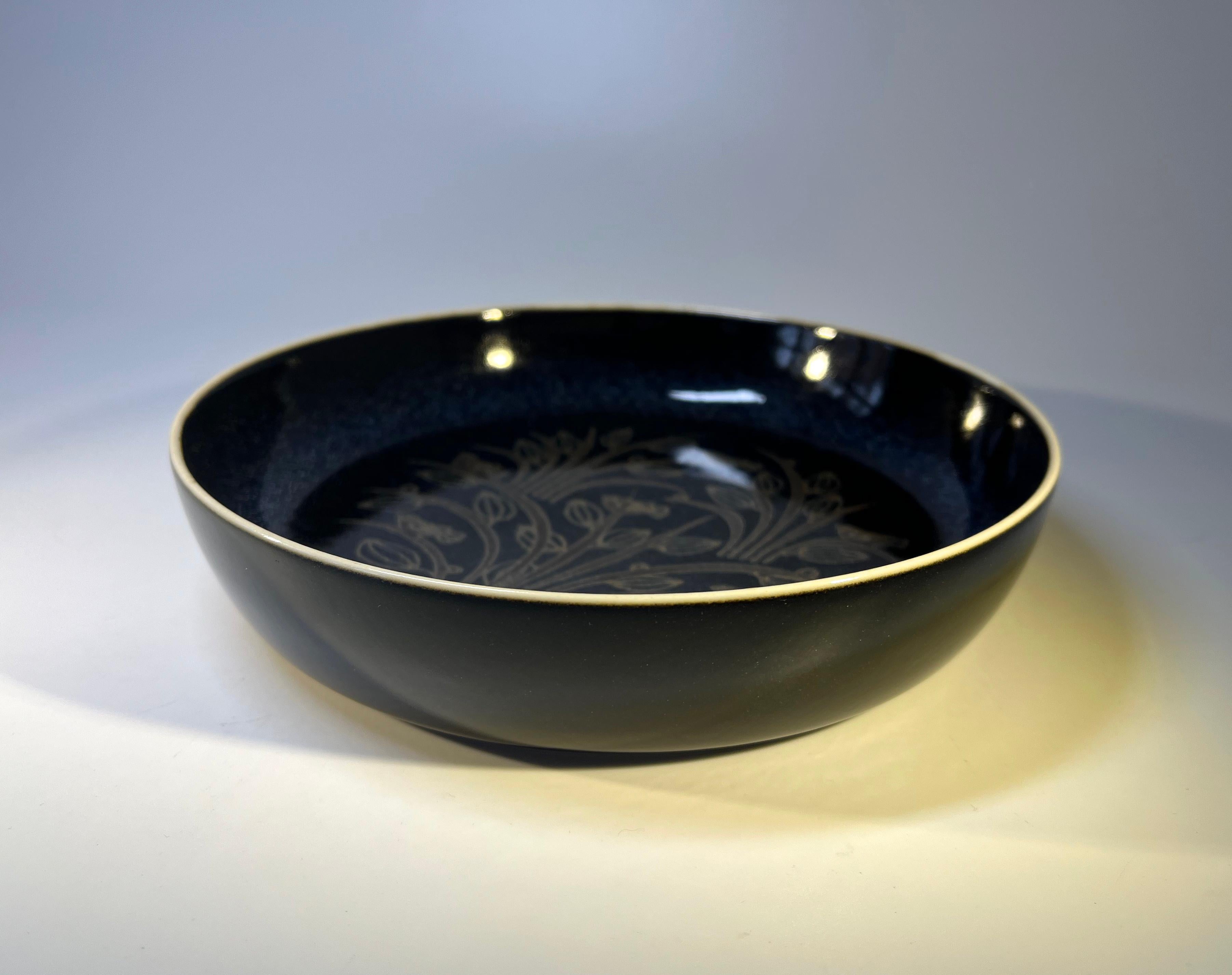 Splendido pezzo degli anni '70 di Snorre Læssøe Stephensen per Royal Copenhagen. Piatto in porcellana blu navy con decorazione di uccelli ed erbe 
Banda fine bianca sul bordo
Design danese sobrio e raffinato 
Data c1970
Firmato e numerato