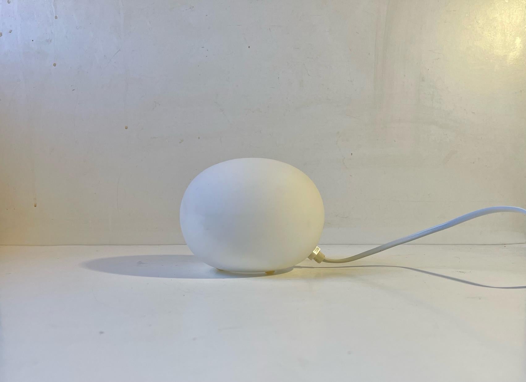 A small realistically sized snowball table lamp from Agneta in Sweden. Its made from frosted/matté opaline glass and was very popular during the 1990s. Measurements: height: 10 cm, diameter: 12 cm.