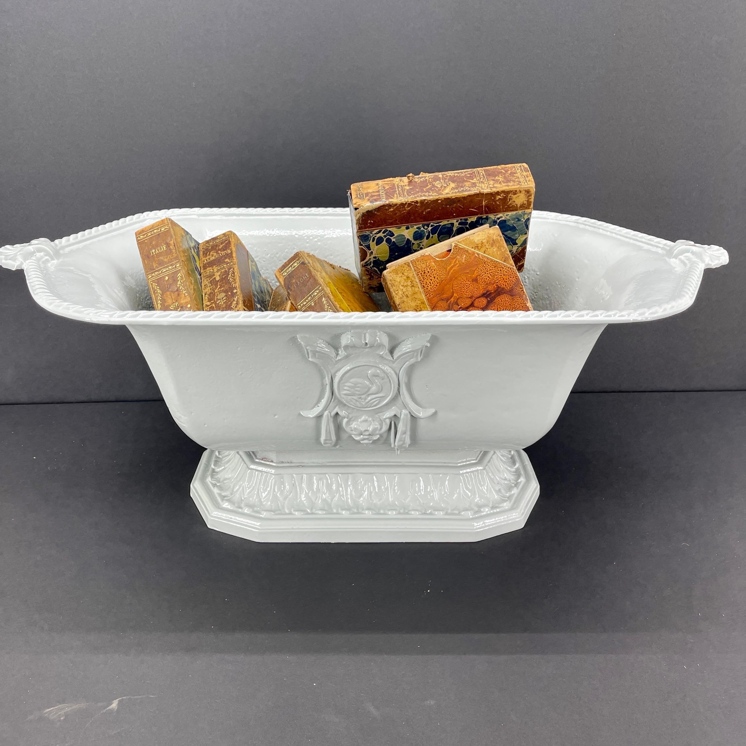 19th Century Cast Iron Planter Jardiniere, Powder-Coated in Snowbird White  

This neutral colored oblong planter features handles above fluted scrolling decorated sides. The planter is raised up on a stepped base and features a bird emblem on one