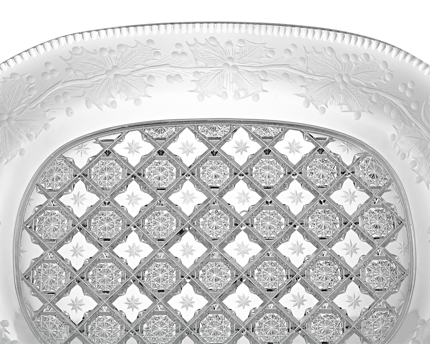 The festive Snowflakes and Holly pattern adorns this glass platter by H. P. Sinclaire & Company. Patented by Henry Purdon Sinclaire, Jr. in 1911, the popular motif features holly berry and leaf engraving along the rim, while the base is cut in a