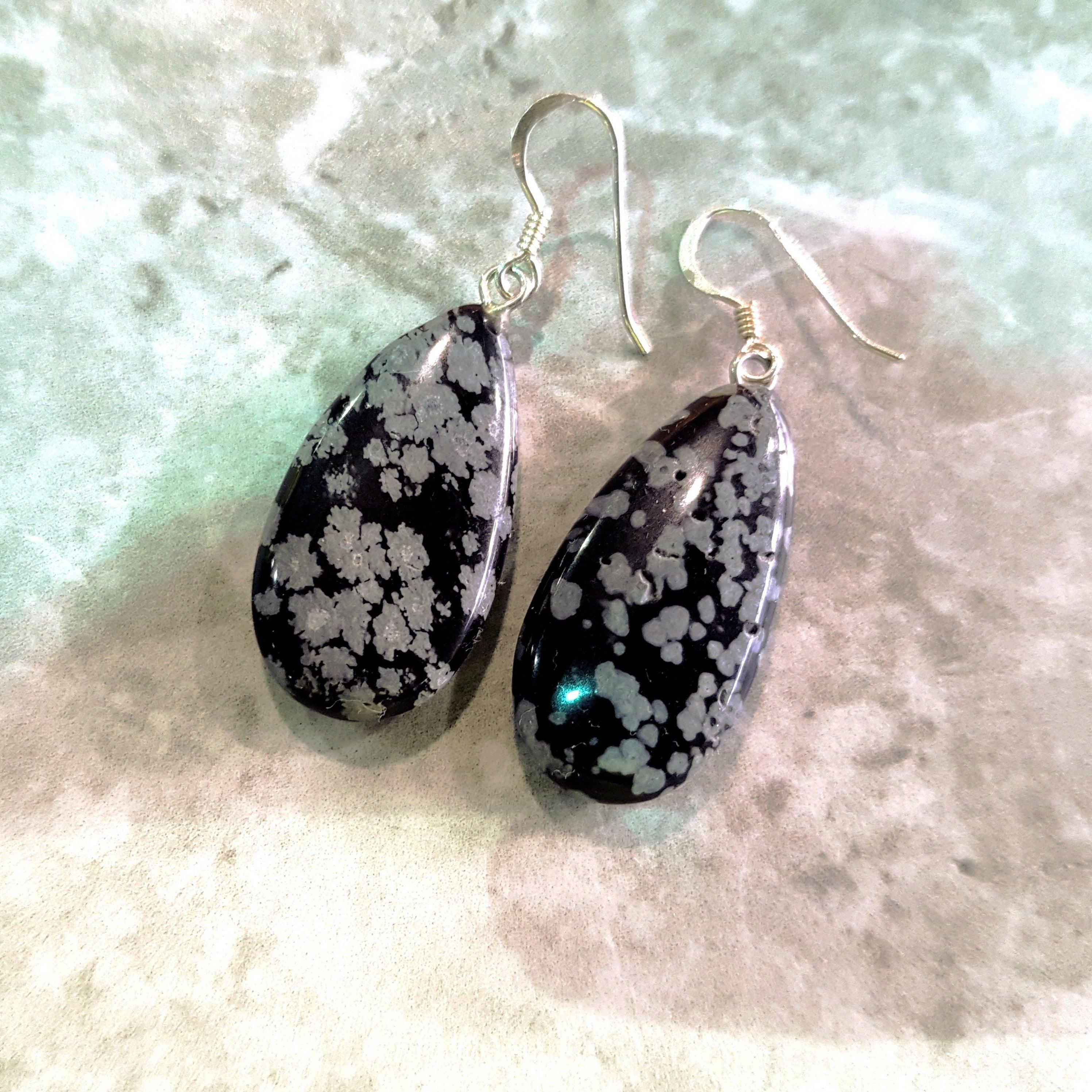 I nostri splendidi orecchini di ossidiana a fiocco di neve sono un mix perfetto di eleganza e bellezza naturale. Questi orecchini a goccia sono realizzati con gemme di ossidiana Snowflake e argento 925. La pietra maculata bianca e nera offre un look