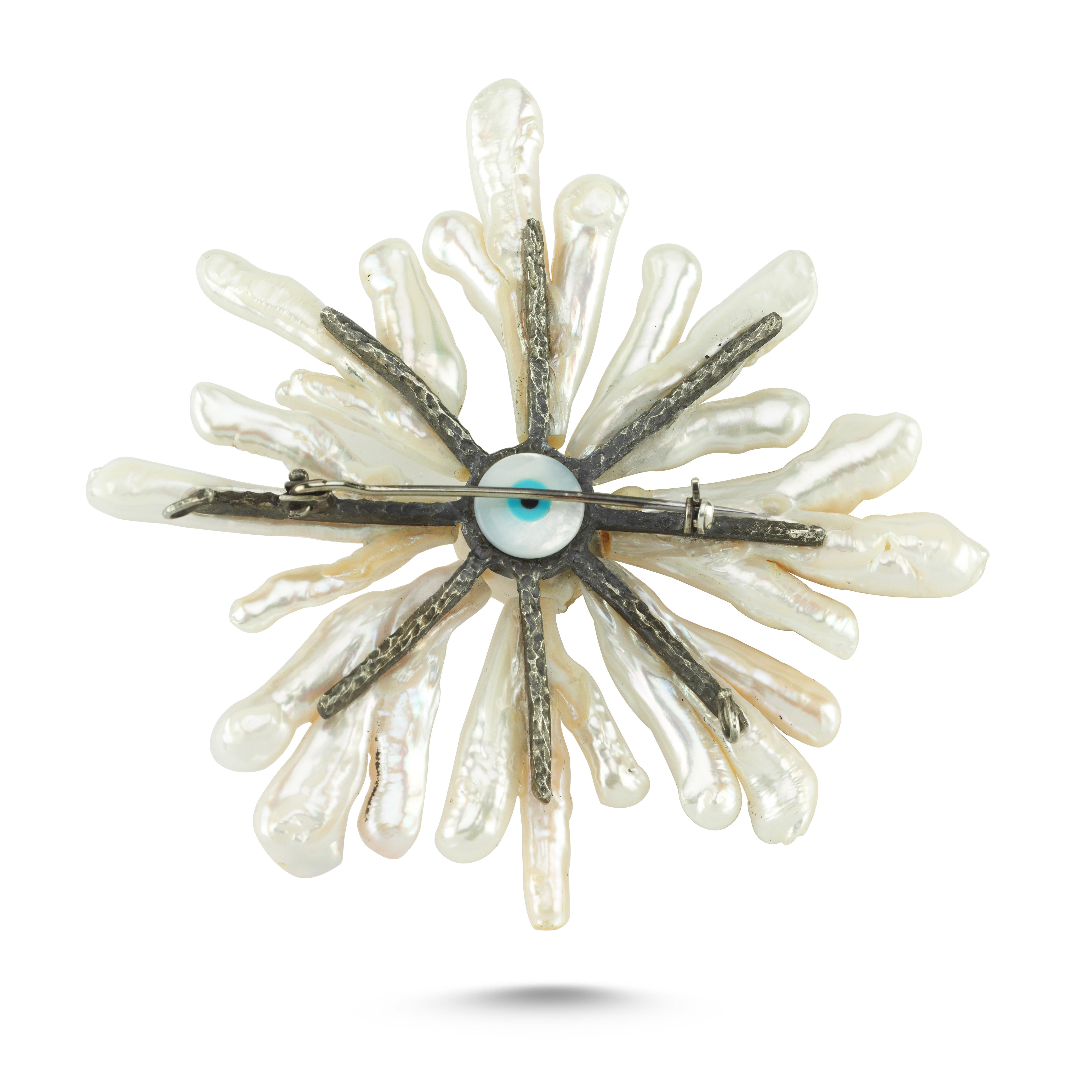Cette broche en argent 925 et perles baroques est fabriquée à la main par des artisans orfèvres qui ont inspiré le designer Emre Osmanlar, à partir de formations inhabituelles de perles assemblées dans un motif de soleil, de couleurs pures et