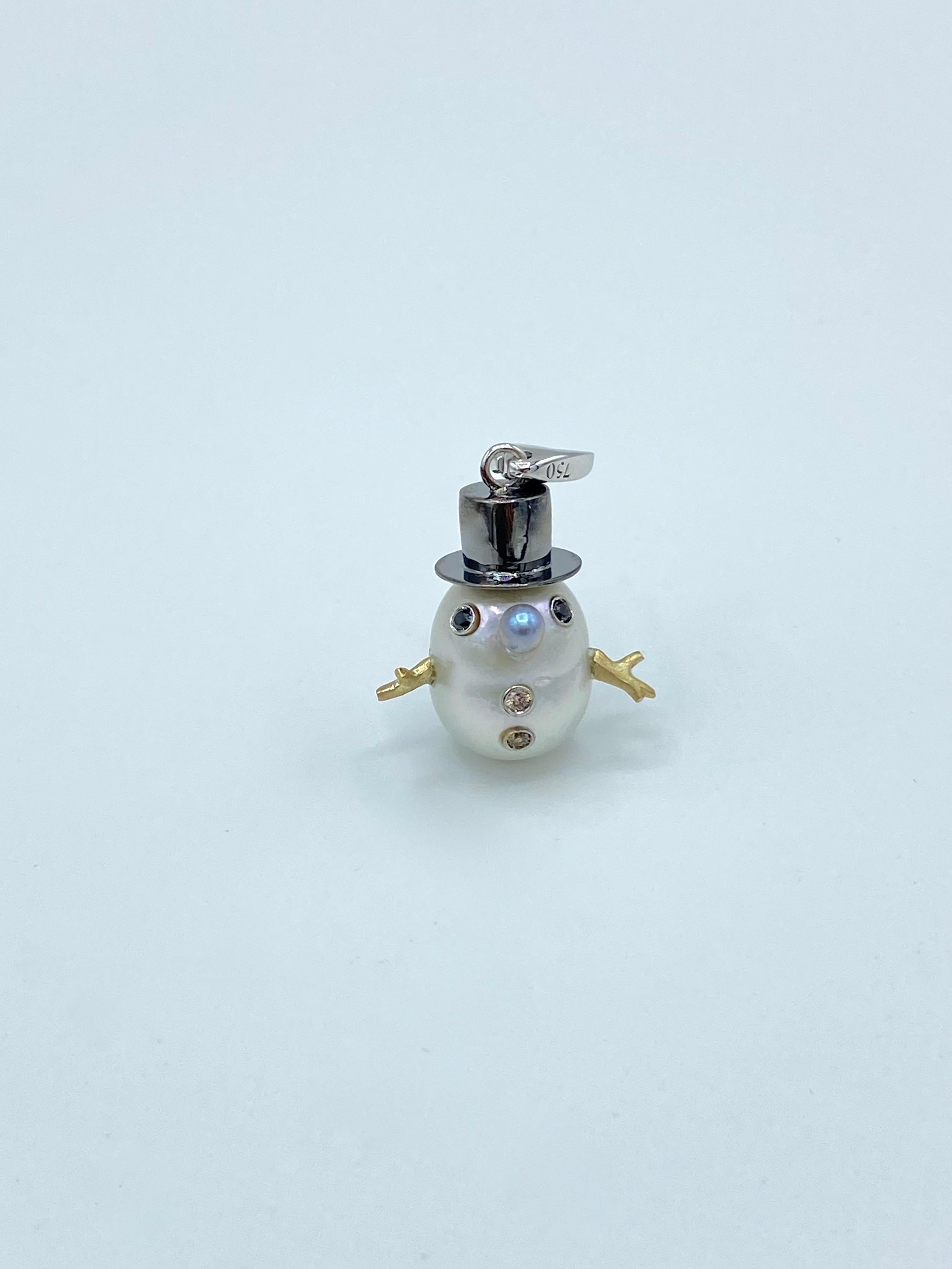 I wanted to create for the winter time a new pendant with an Australian pearl.
Its special shape inspired me to create a snowman.
It has a cylinder hat  plated black rodhium. 
Its eyes are two black diamonds.
The buttons are two brown diamonds.
I