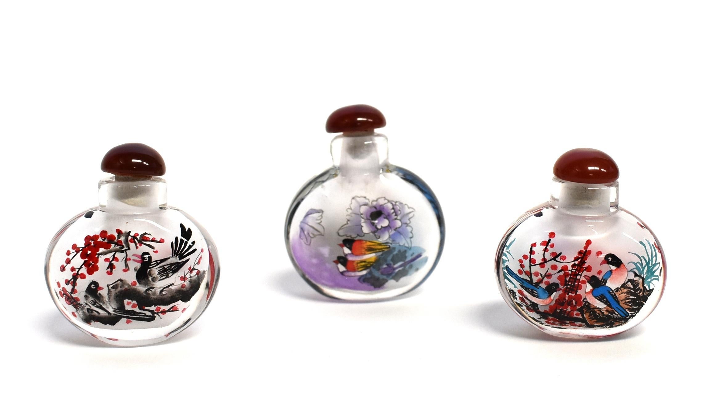 Our snuff bottles are topped with gemstone grade agate lids and 100% hand painted from within. The Chinese art of églomisé uses a very thin bamboo brush with a few strands of hair to apply watercolor on the inside walls of the blank glass bottle