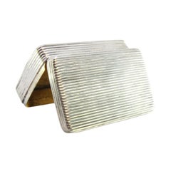 Tabatière en argent cannelé avec couvercle repoussé renfermant une carte monogramme.