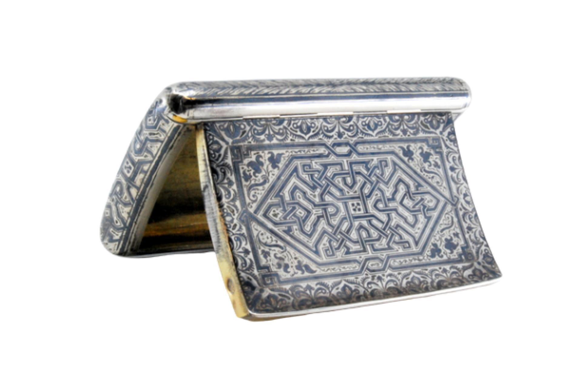 Beschreibung: Schnupftabakdose aus vernickeltem Silber mit geometrischen Motiven, goldener Innenausstattung und Scharnierdeckel. Metall: Silber. Herkunft: Französisch. Marke: Boar's Head. Gewicht: 93,18 Gramm. Abmessungen: 8,8x1cm. Inhalt: 800/1000.