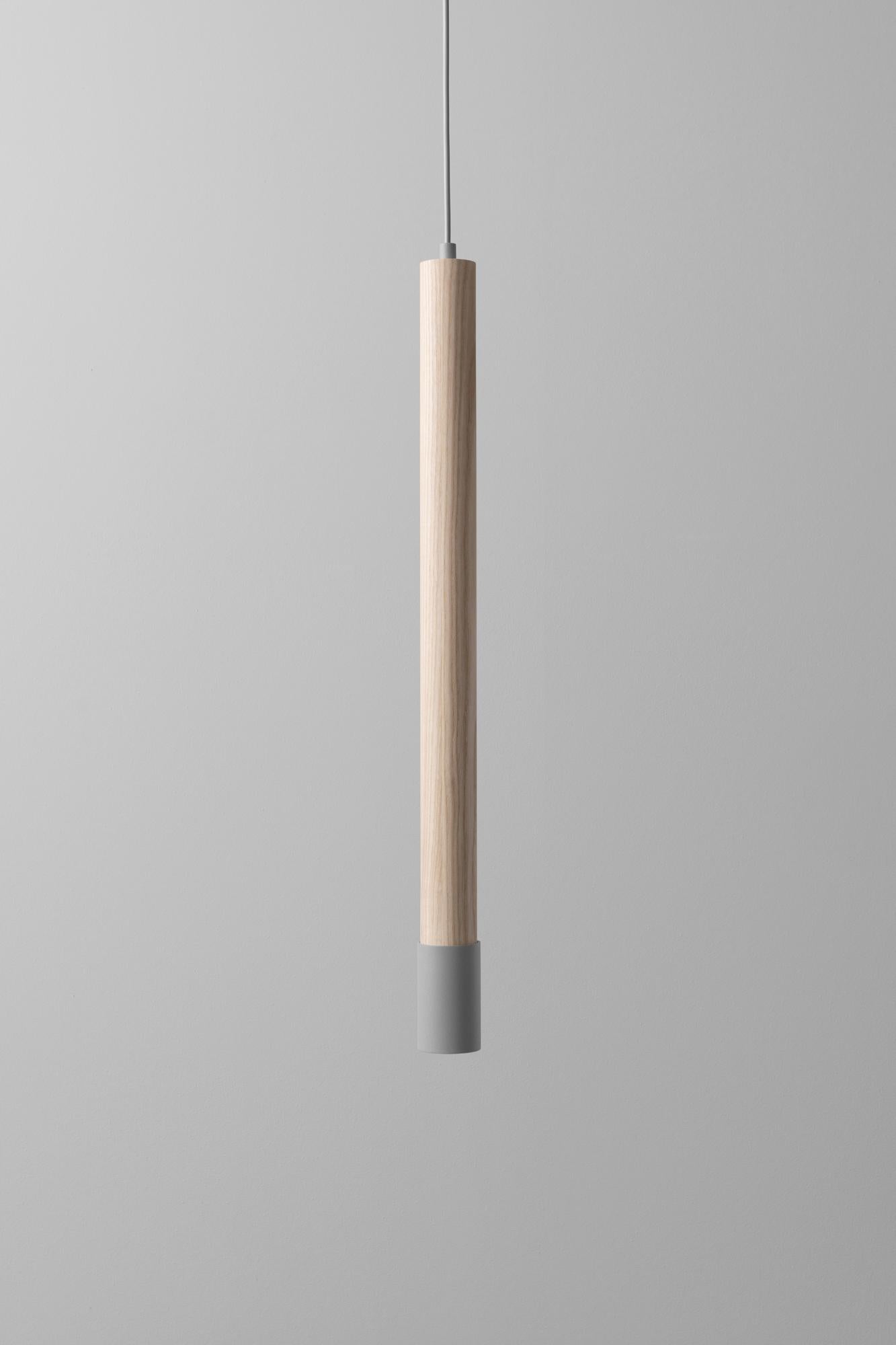 Lampada a sospensione grigia SO6 di +kouple
Dimensioni: Ø 5,4 x H. 70,2 cm. 
Materiali: Acciaio verniciato a polvere e frassino massiccio oliato.

Disponibile in diverse opzioni di colore. La lunghezza del cavo in PVC è di 200 cm.