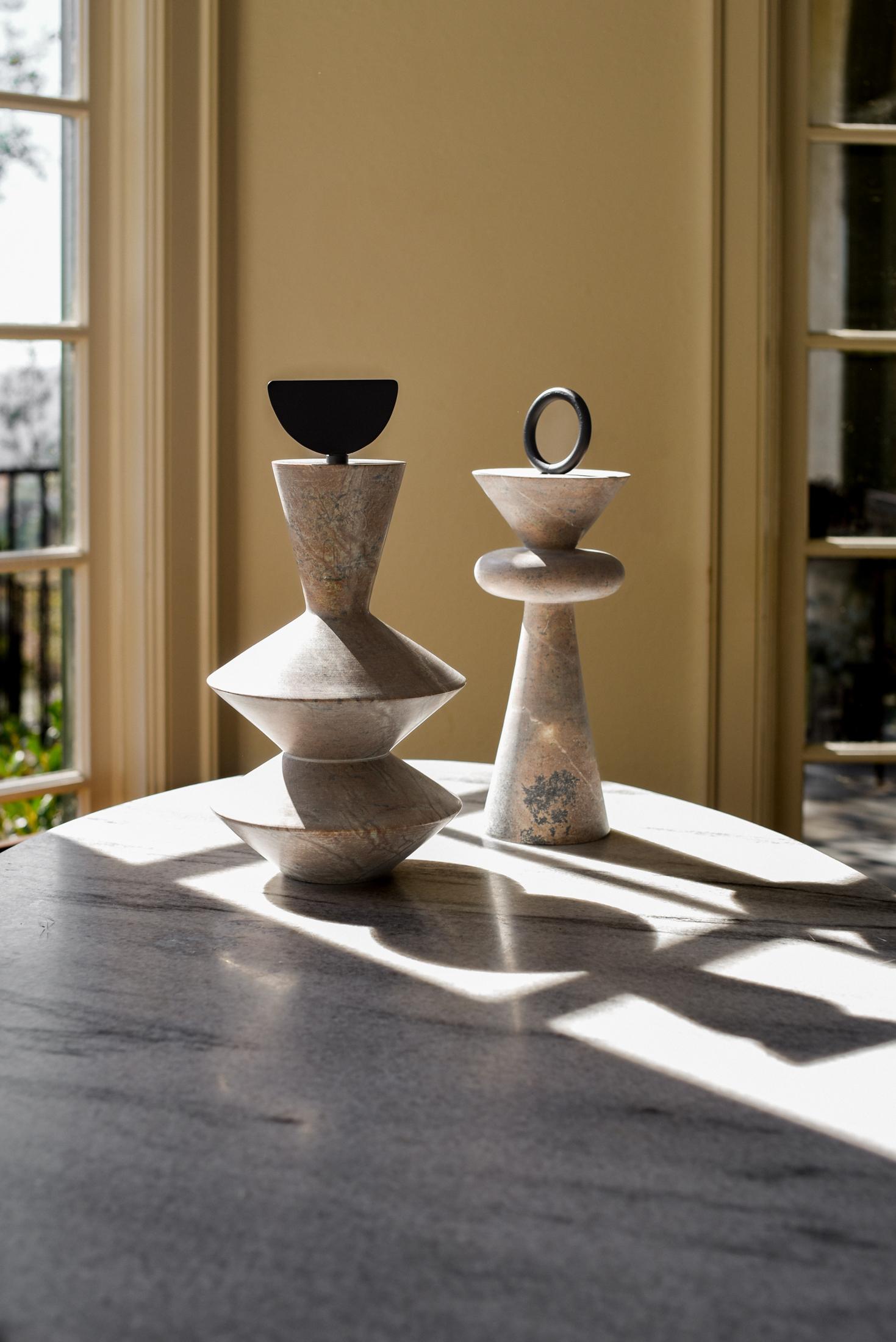 Soapstone is skillfully milled into graceful geometric shapes, creating totem sculptures that maintain a purity of form and balance of lines. A sense of movement and intrigue is provided by the addition of carbon steel ornamentation. Elegantly