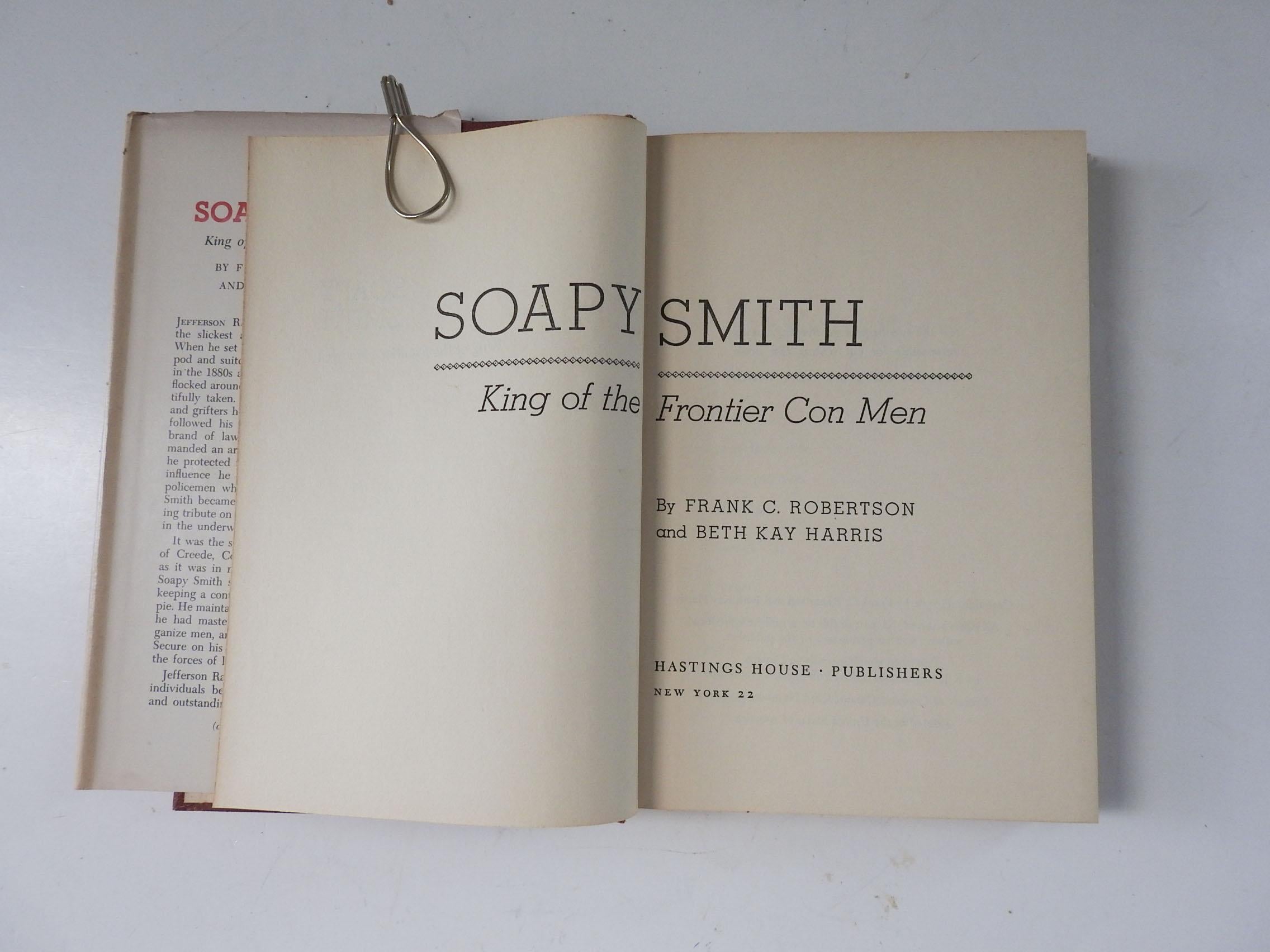 Soapy Smith: King of the Frontier Con Men by Frank C. Robertson and Beth Kay Harris.  Published by Hastings House, New York, 1961.  1880's con man working from Denver to Skagway.  Red cloth hardcover binding, illustrated dust jacket, edge wear, dust