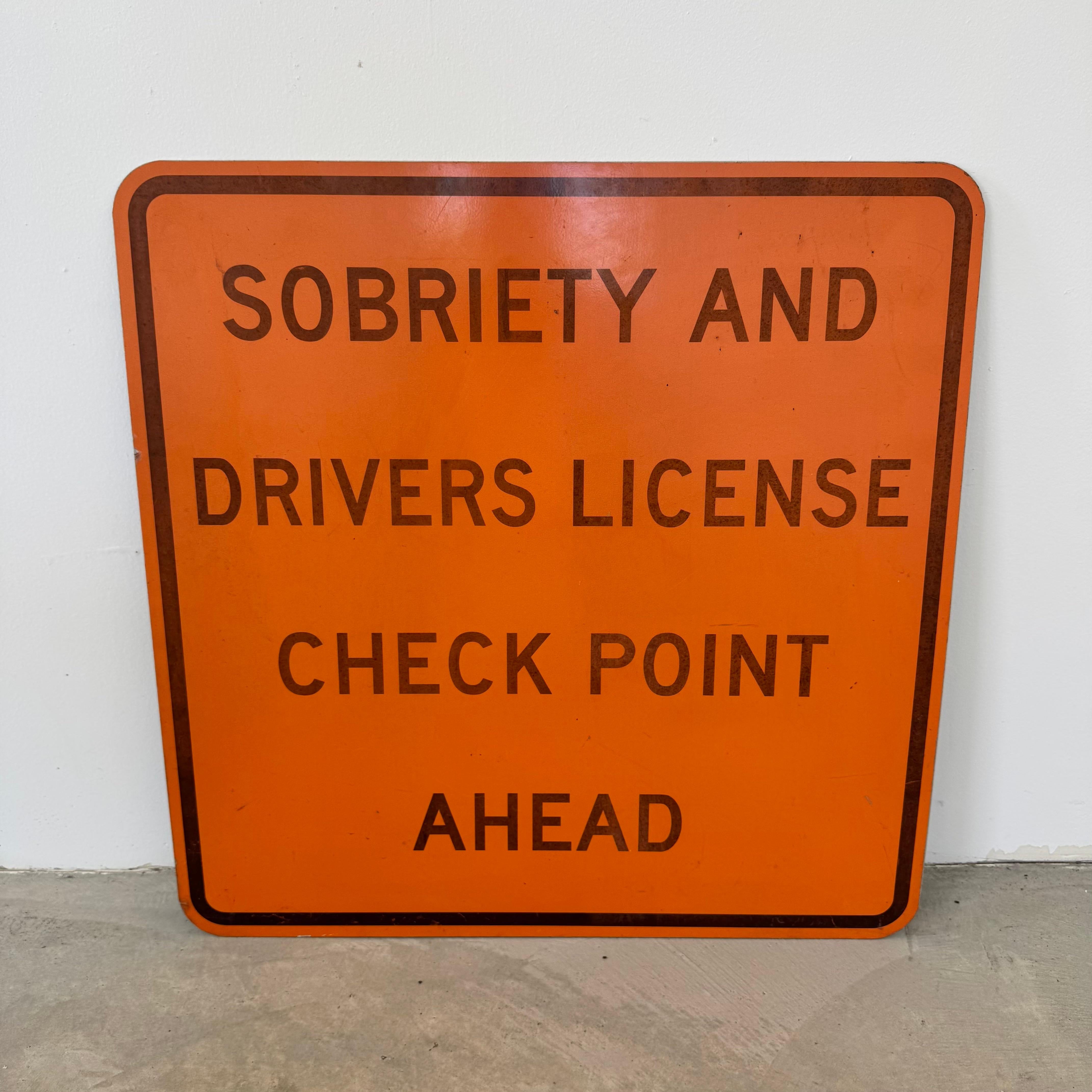 Authentique panneau de signalisation routière d'époque en orange de sécurité gras avec des lettres noires en bloc, indiquant : 
