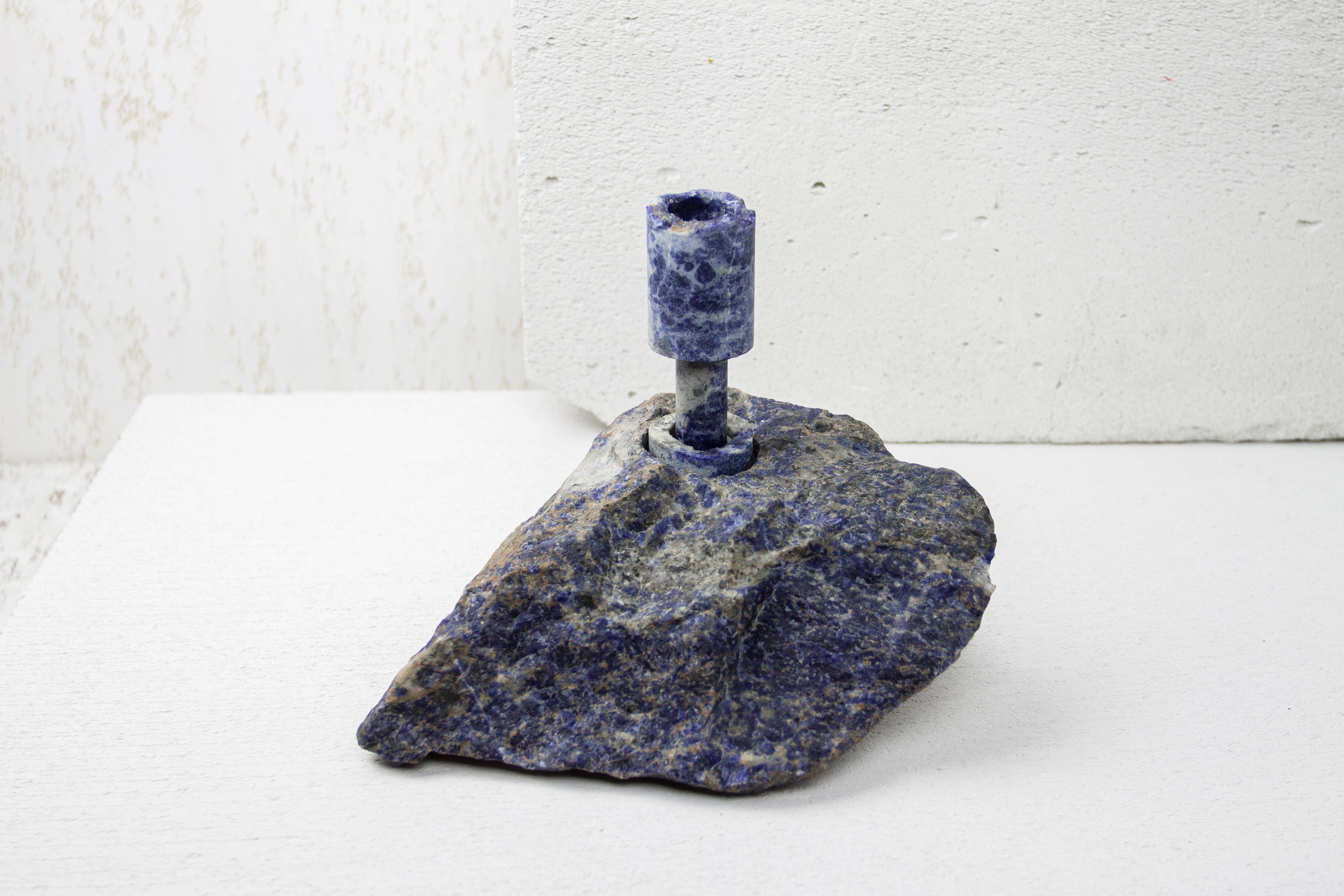 Sodalite Abra Candelabra by Studio DO
Dimensions: D 20 x W 15 x H 17 cm
Materials: Sodalite, aluminum.
2.8 kg.

Stone and fire are connected in an ageless bond. A sparkle created by clashing two stones with each other has been igniting fire over