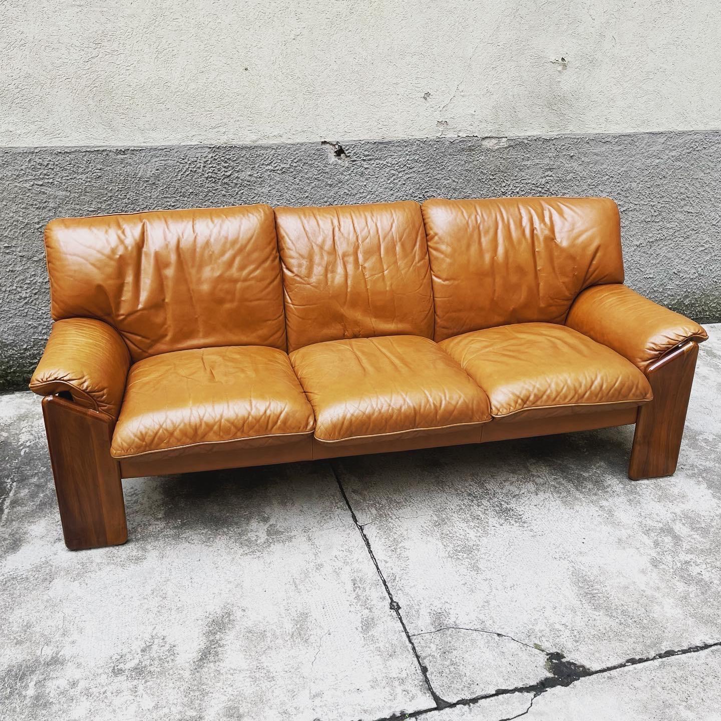 A walnut and leather sofa from the Sapporo Line, designed by Mario Marenco for Mobil Girgi, produced in the 1970s, Italy. Marked under the pillows. Beautifully designed with angled front legs that extend to the sides and back, the back support is