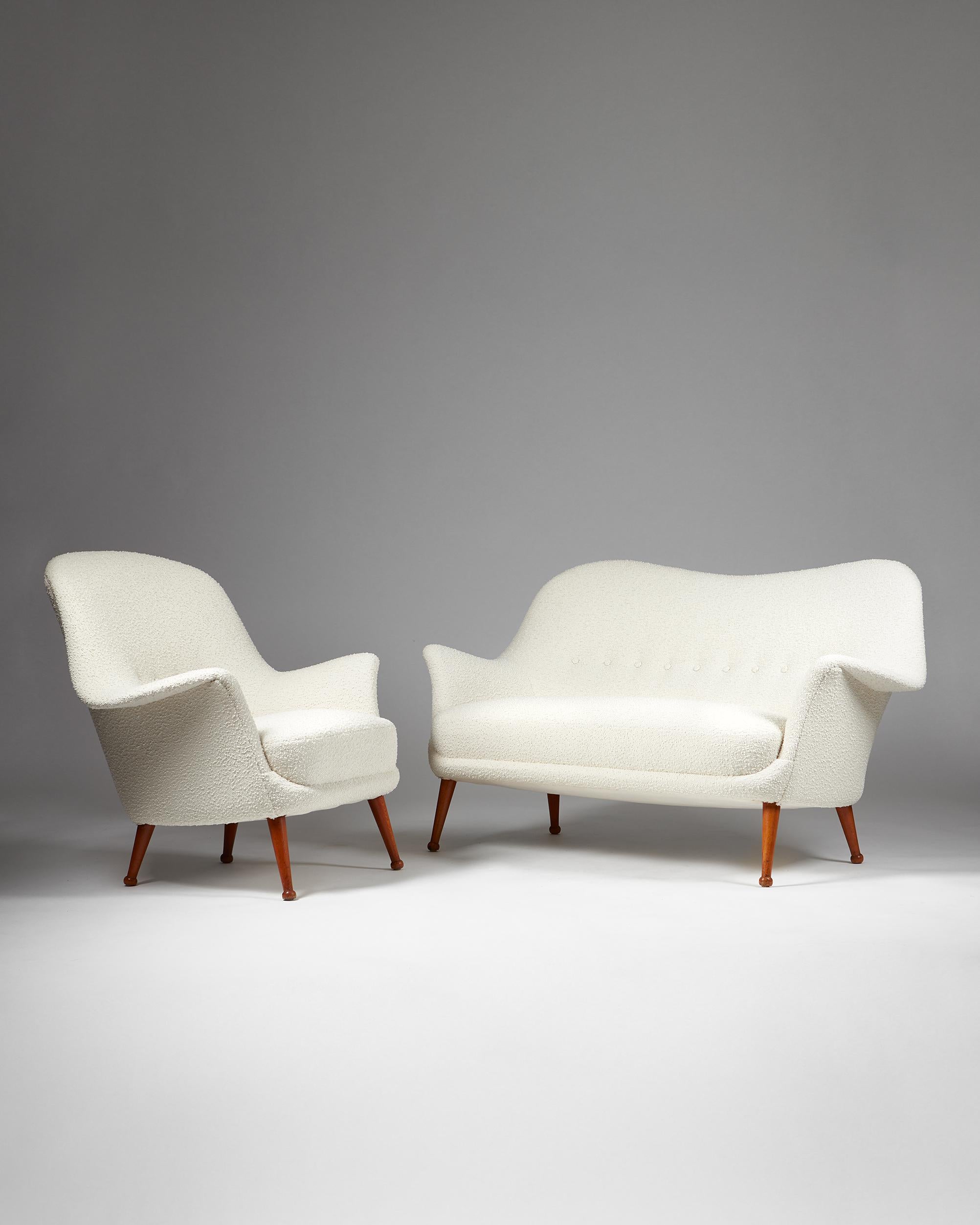 Canapé et fauteuil Divina conçus par Arne Norell, pour Norell Mbler,
Suède. 1950s.
Bois laqué et tissu d'ameublement en tissu bouclé.

Ce modèle de canapé et de fauteuil Divina combine l'utilisation par le designer suédois Arne Norells de formes