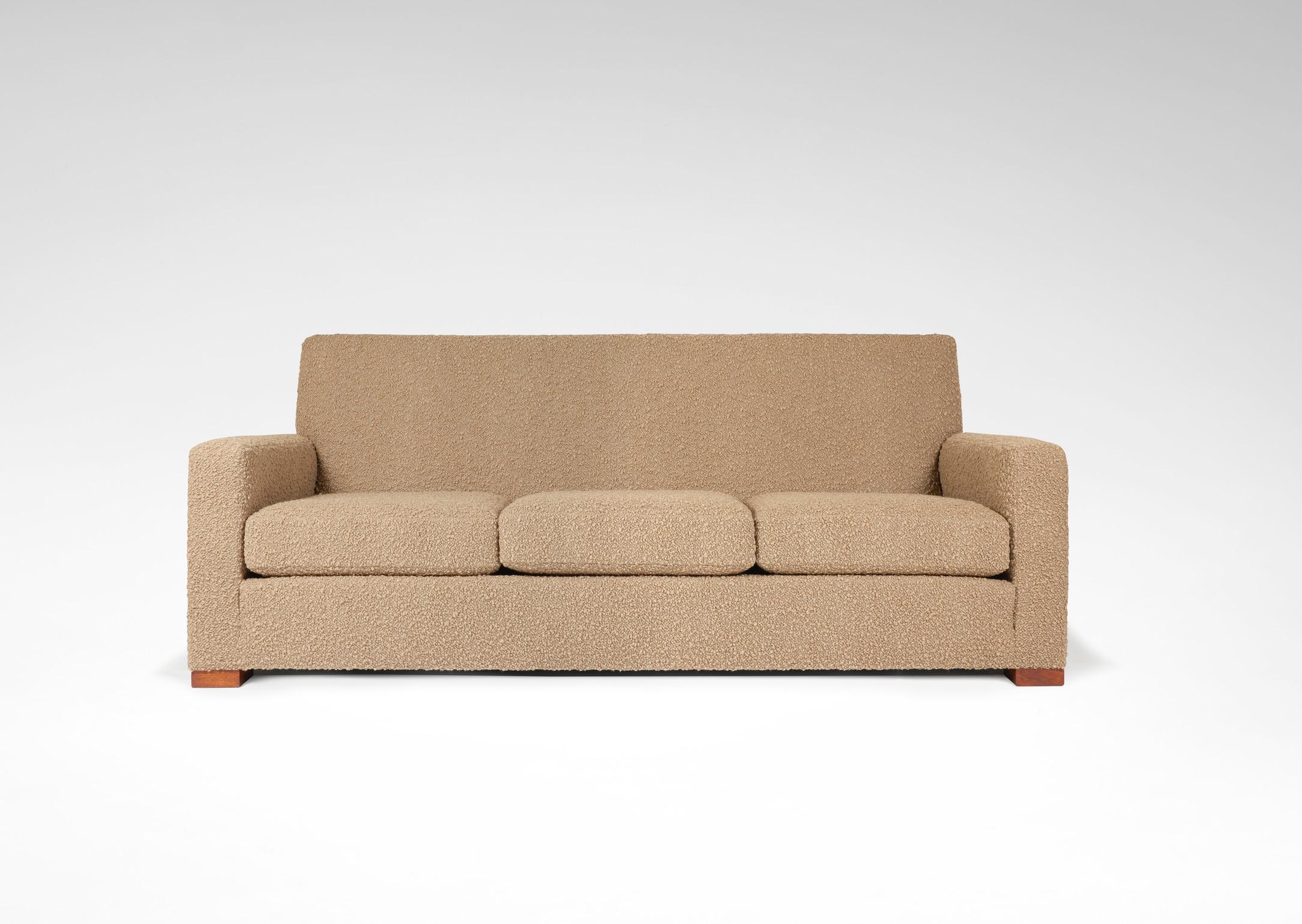 Set composed of a sofa and two armchairs covered with a light brown fabric bouclette. 
Parallelepipedic wooden legs and full straight armrests. 
Dimensions sofa : H. back : 86 cm ; L. : 210 cm ; Pr. : 90 cm.
Dimensions armchairs : H. back : 86 cm