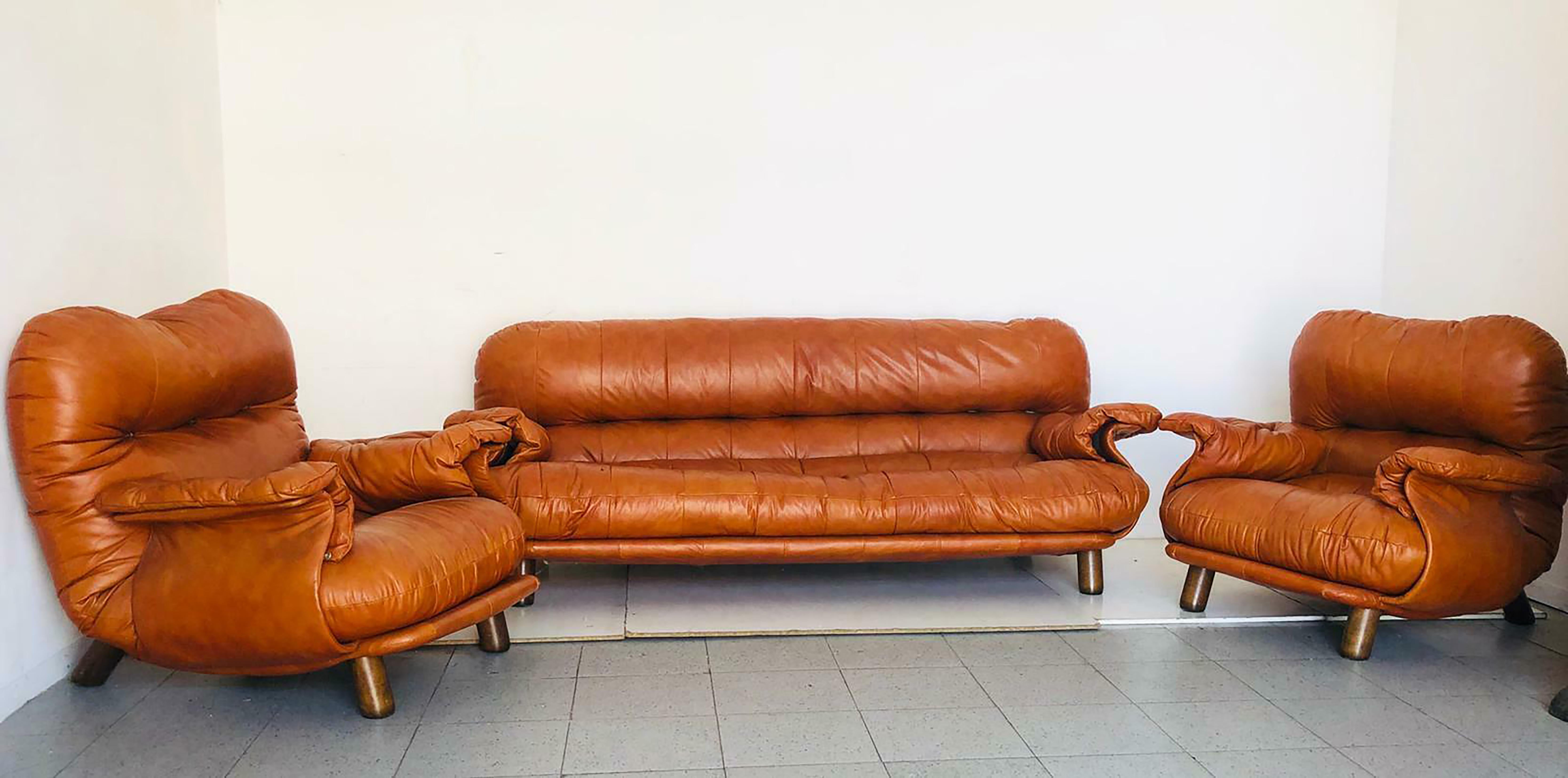 This sofa and armchairs set is an amazing set designed by E. Cobianchi for Insa presenting a peculiar design of the 1970s.

Both the sofa and the armchairs have an original brown leather covering and are made of a wooden base.

This fashionable