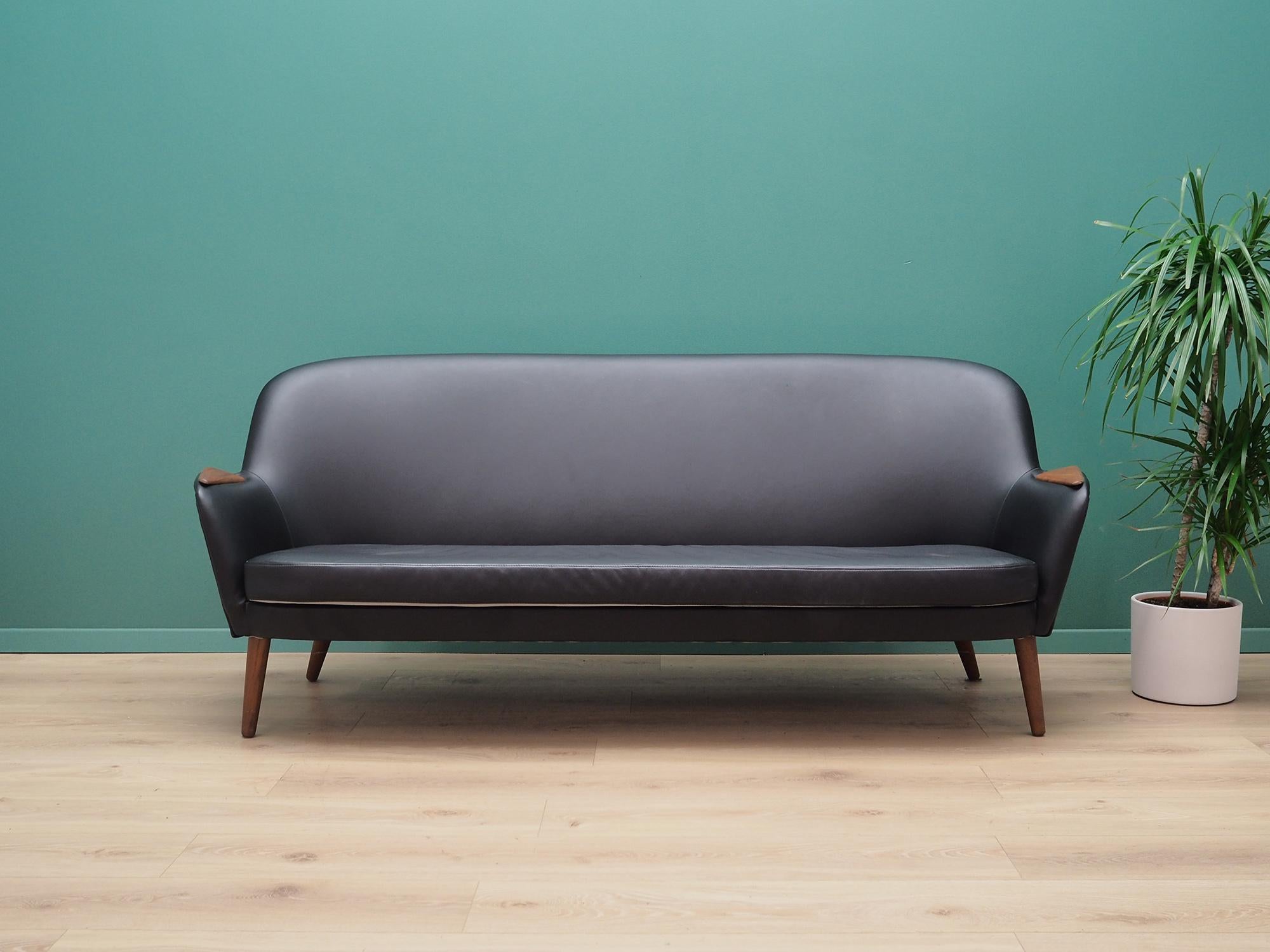 Sofa was made in the 1960s, Danish production.

Construction of the furniture is made of wood. Legs made of solid teak wood. Sofa has undergone renovation. Upholstery has been replaced by new one and it's made in black, high quality natural