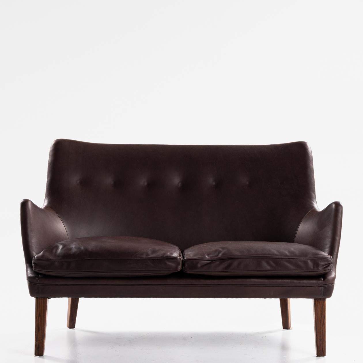 AV 53/2 - 2-seater sofa in new aniline leather (Victoria, colour: Ebony) with legs in solid Brazilian rosewood. Arne Vodder / Ivan Schlechter.