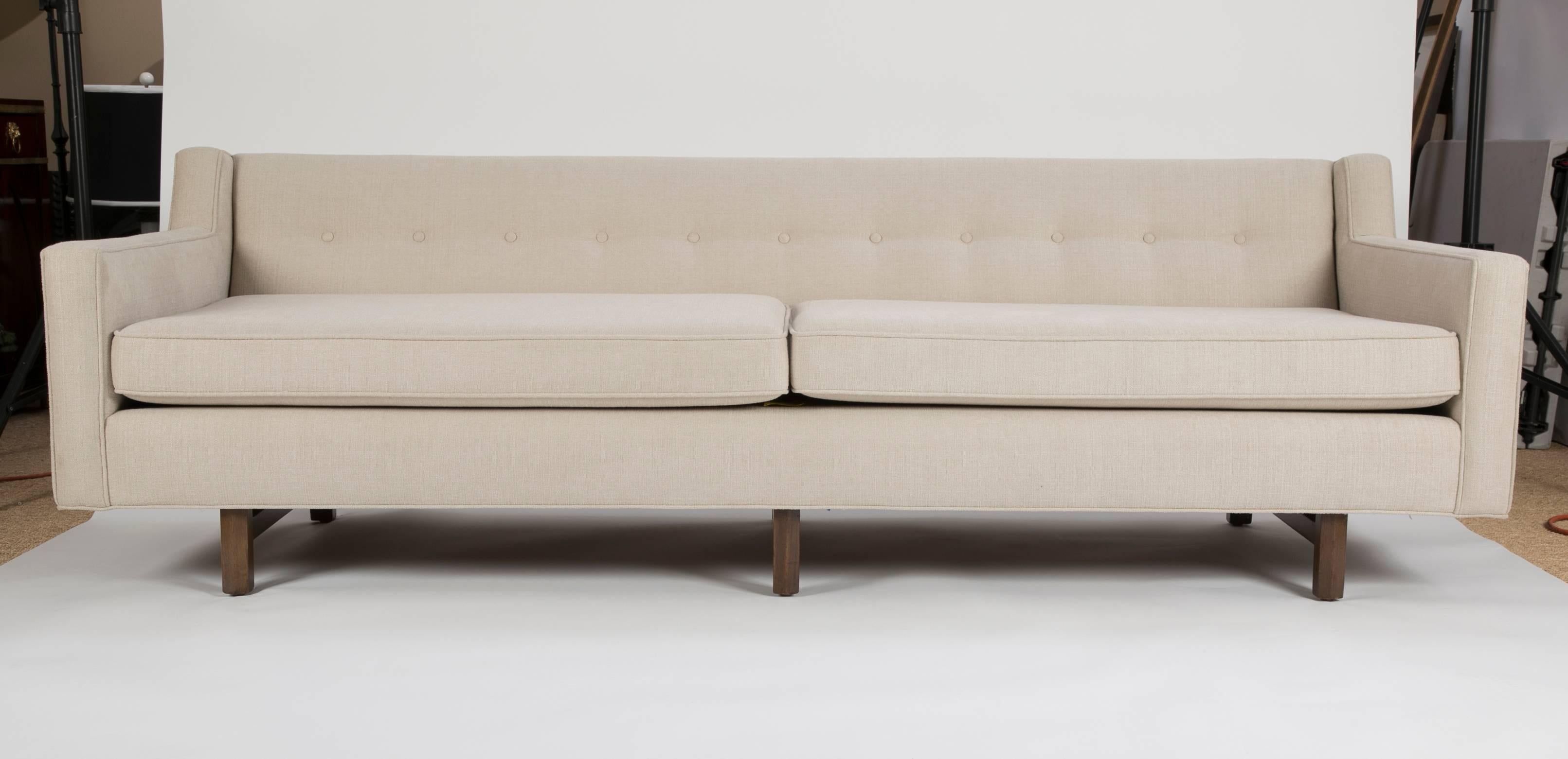 A midcentury sofa by Edward Wormley for Dunbar with faceted legs and stretchers. Newly upholstered.
