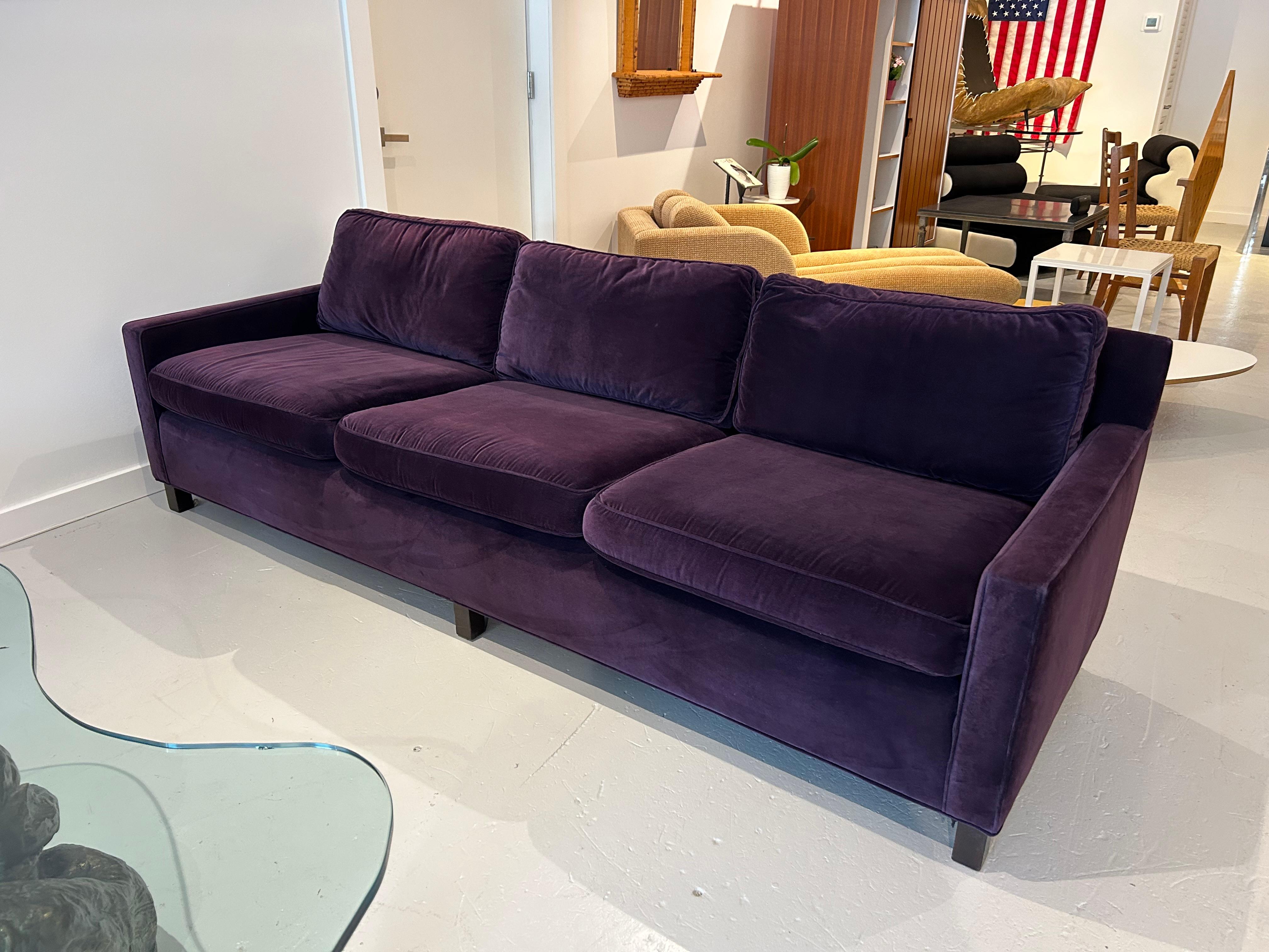 Handsome sofa by Harvey Probber upholstered in plum velvet with self-welting, six loose cushions (the seat cushions have a zipper), a buttoned back, and a spring base, all supported on six mahogany legs. The seat depth from the back cushion is 20