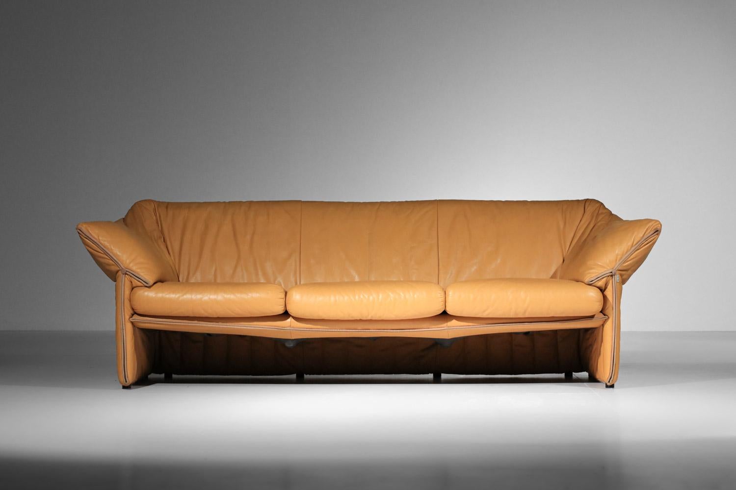60s/70s sofa by Italian designer Mario Bellini, published by B&B Italy, “La Stelle” model. Entirely in mustard yellow leather (original leather), this model is recognizable by its wide armrests and attractive leather finishing details (see photos).