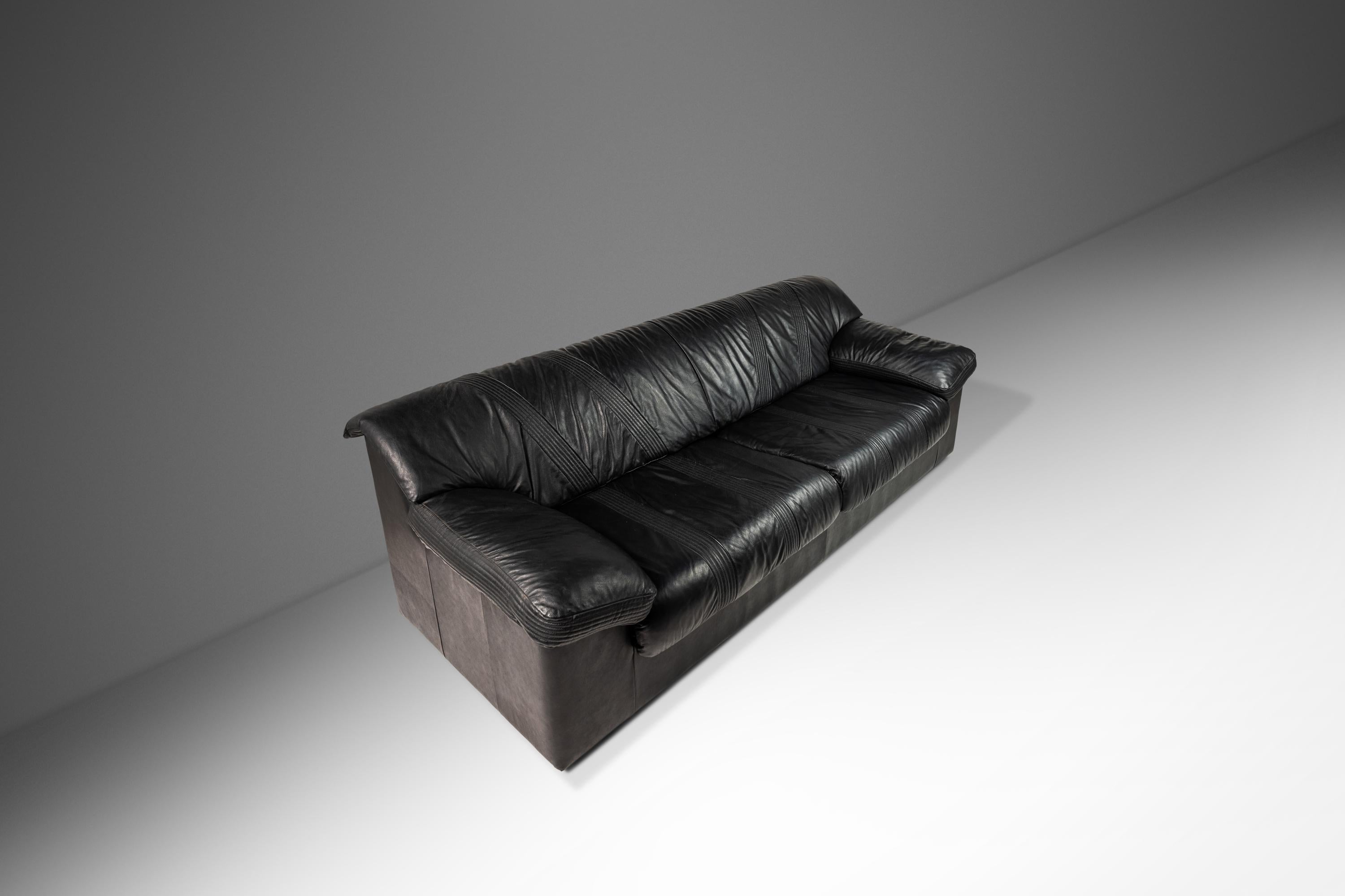  Introduci un pezzo di design post-moderno nel tuo spazio abitativo con questo raffinato divano a quattro posti con poltrona abbinata di Natuzzi, un rinomato produttore di mobili italiano. Realizzati negli anni '90, questi divani presentano un