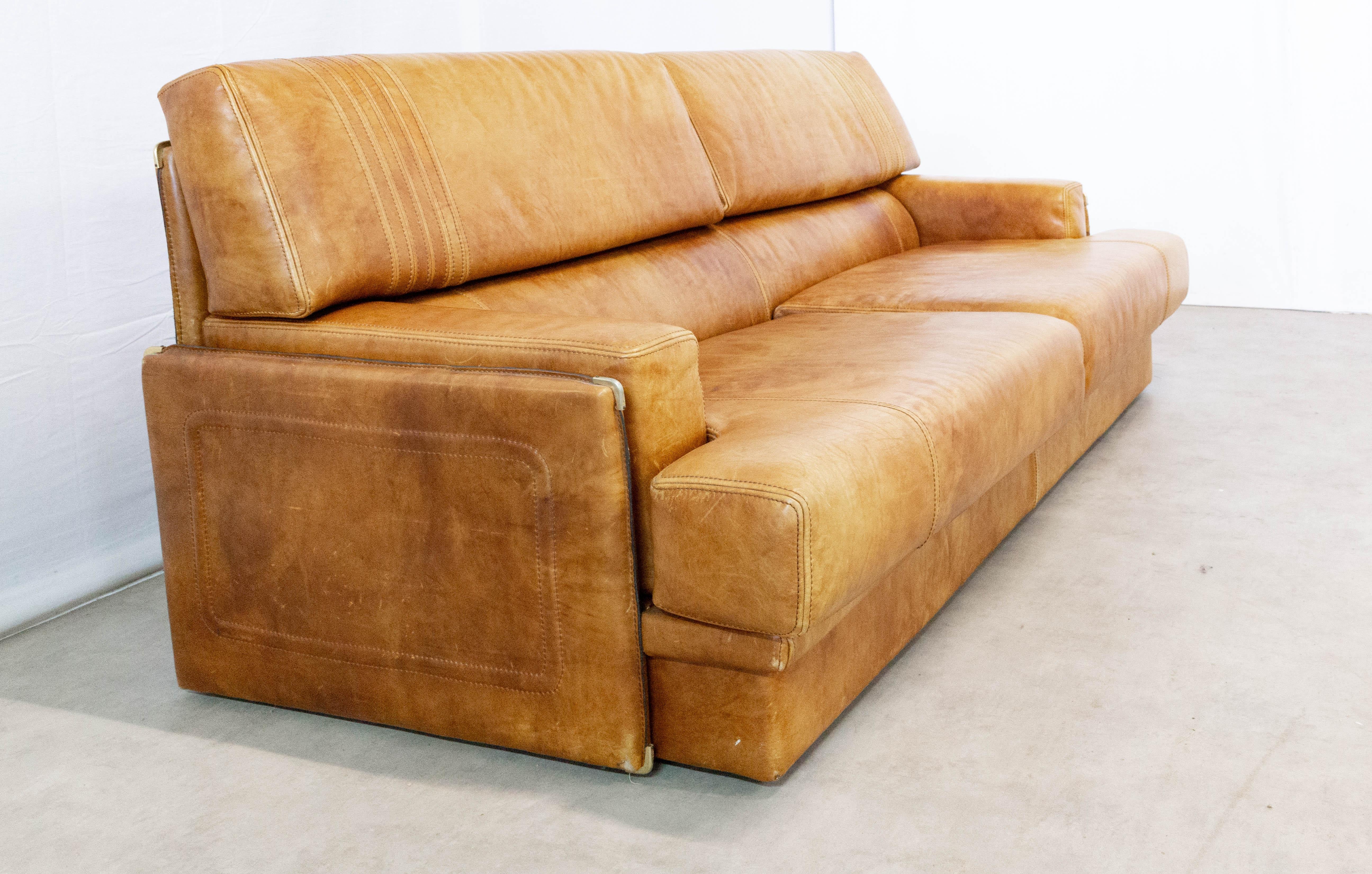 1970s leather sofa of Marco Milisich for Baxter Arcon
Large and comfortable vintage sofa in cognac leather with great patina. Heavy wrapped leather frame shelters soft seat and back cushions, all with decorative top-stitching.
Very