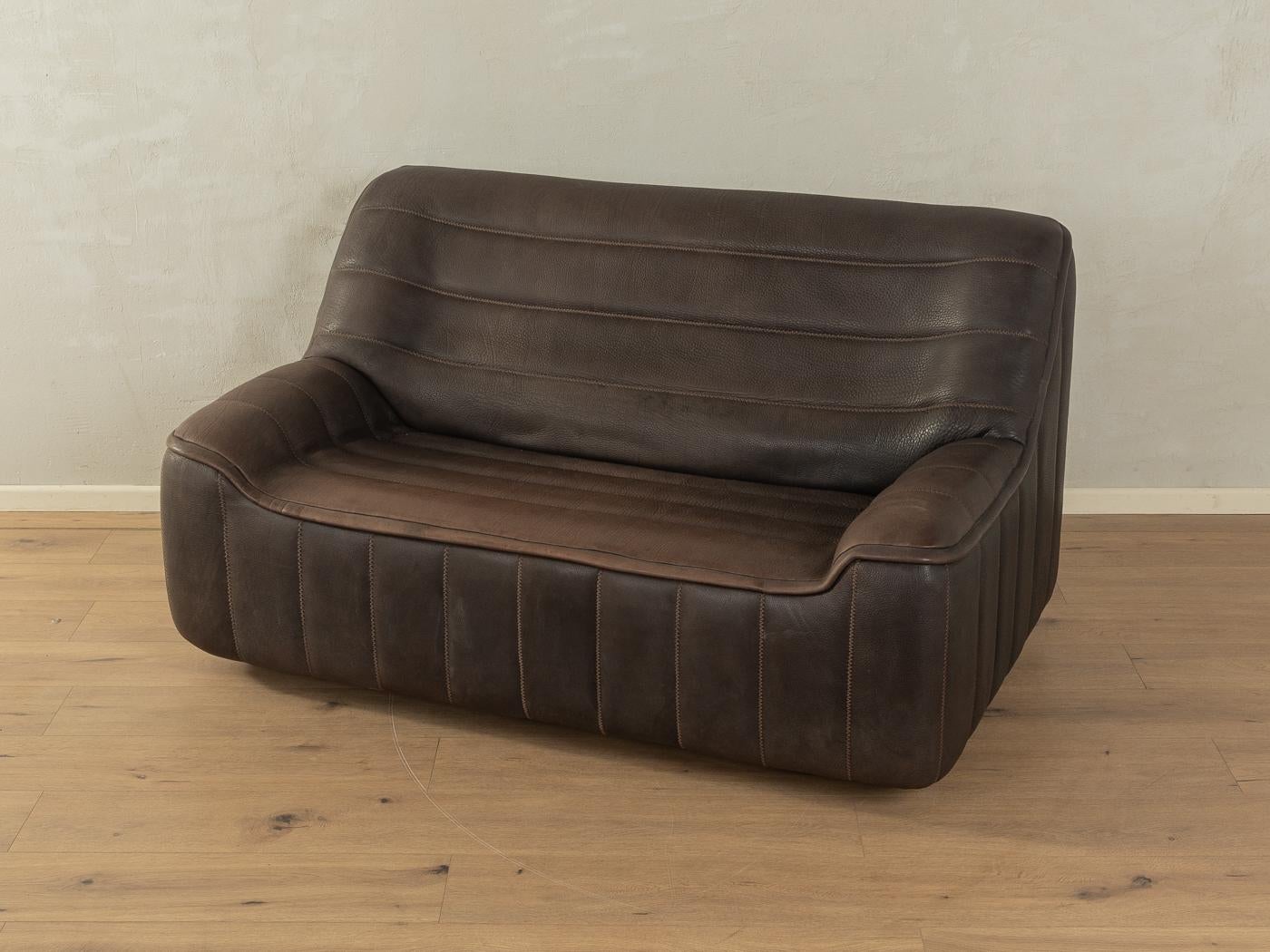 Sofá clásico DS-84 de los años 70 de De Sede con la llamativa funda original de cuero de búfalo marrón y costuras gruesas.

Características de calidad:

    muy buena mano de obra
    materiales de alta calidad
    Hecho en Suiza, fabricante: De Sede