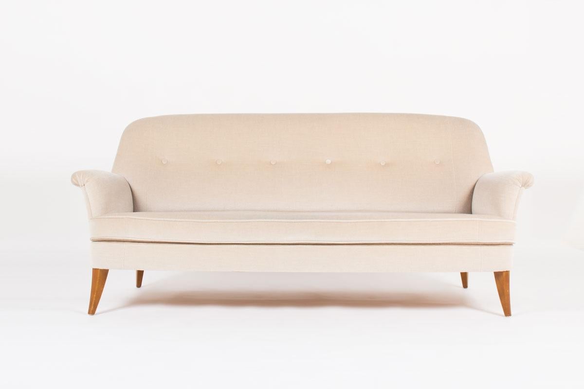 This sofa with refine design was designed during the 1950s by a Swedish designer. It is composed of 4 feet in solid beech and a structure covered with a very nice beige mohair velvet fabric. With its armrests and its back, this sofa with elegant
