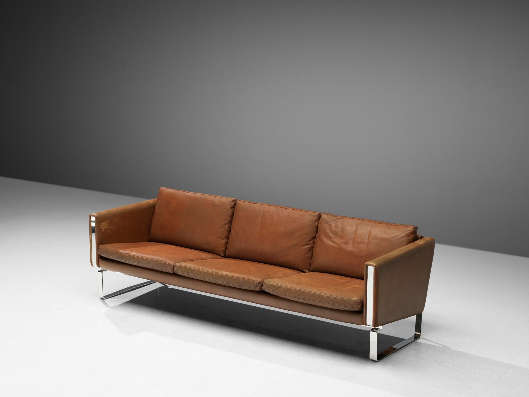 Three-seat sofa, leather and chrome, Scandinavian, 1970s. 

This brown leather sofa with a square steel base on each side is very comfortable. The soft leather cushions provide the back with excellent support and its heaven to sit on. The