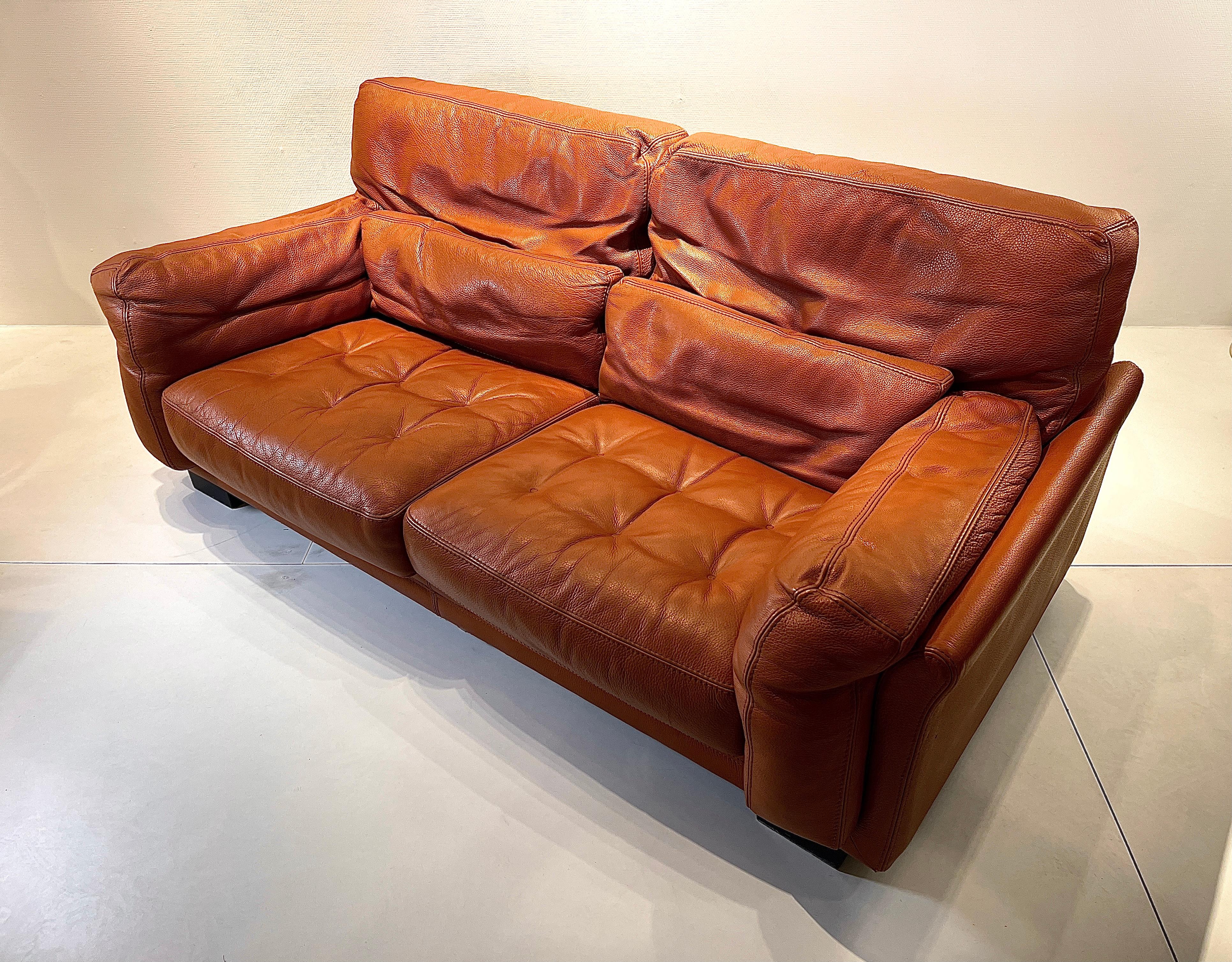 Sofa in cognac leather in very good condition from the 1980s, feet base in wood. Goose feather pillow. In very good condition.