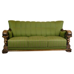 Sofa des années 1920 en tissu vert avec sculptures en bois