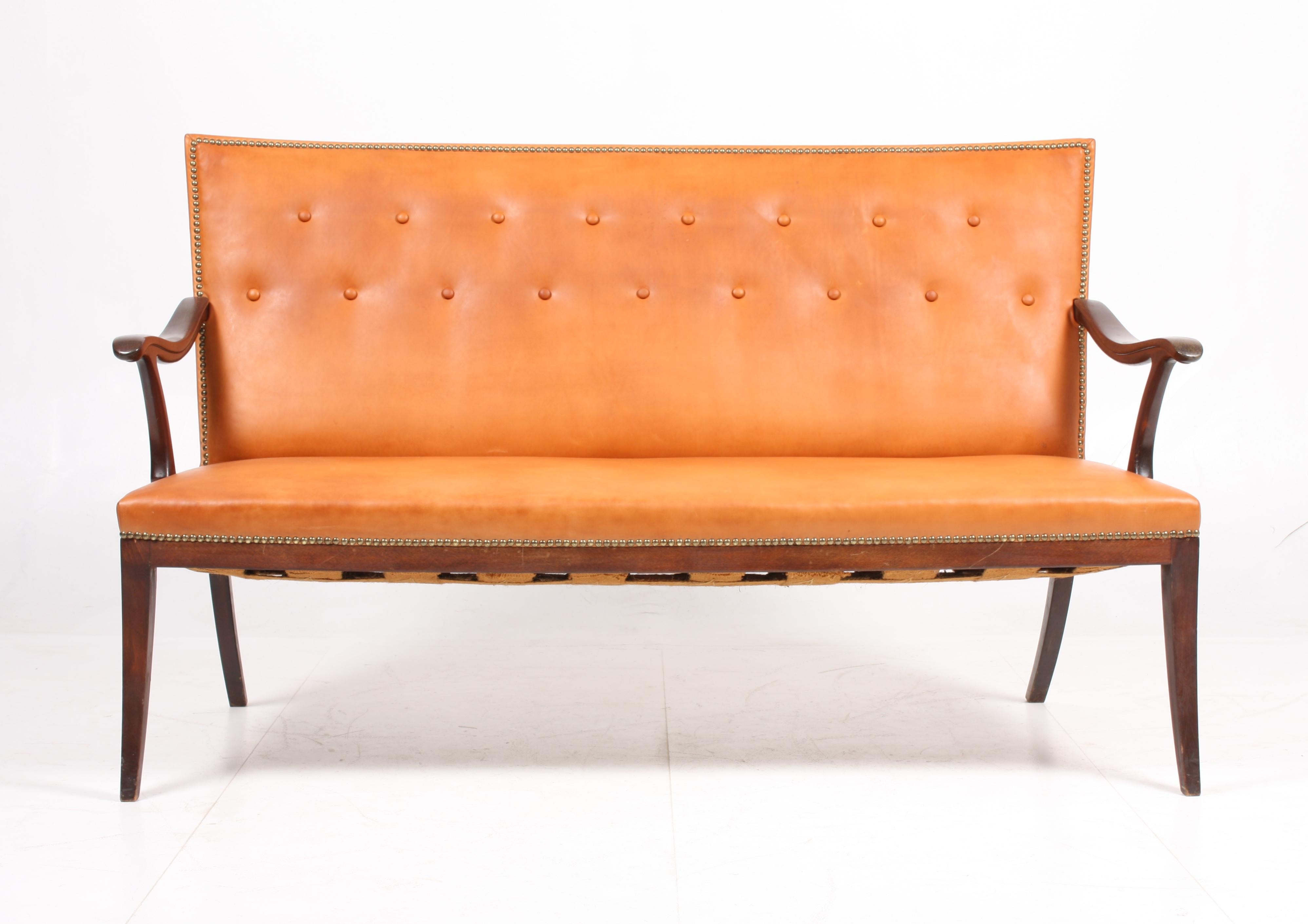 Sofa in mahogany finished beech and patinated natural leather by Frits Henningsen cabinetmakers Copenhagen. Designed in the 1940s. Great condition.