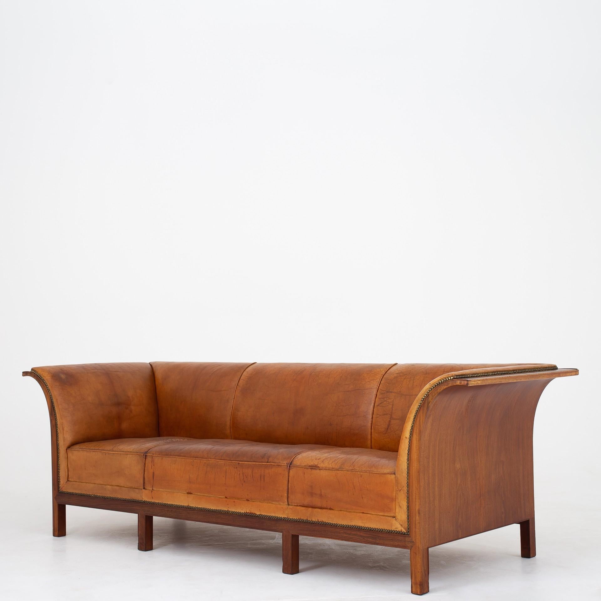 Sofa in patinated niger skin with nail clipped brass nails on cuban mahogany frame. Design 1938. Two chairs available. Maker Frits Henningsen.