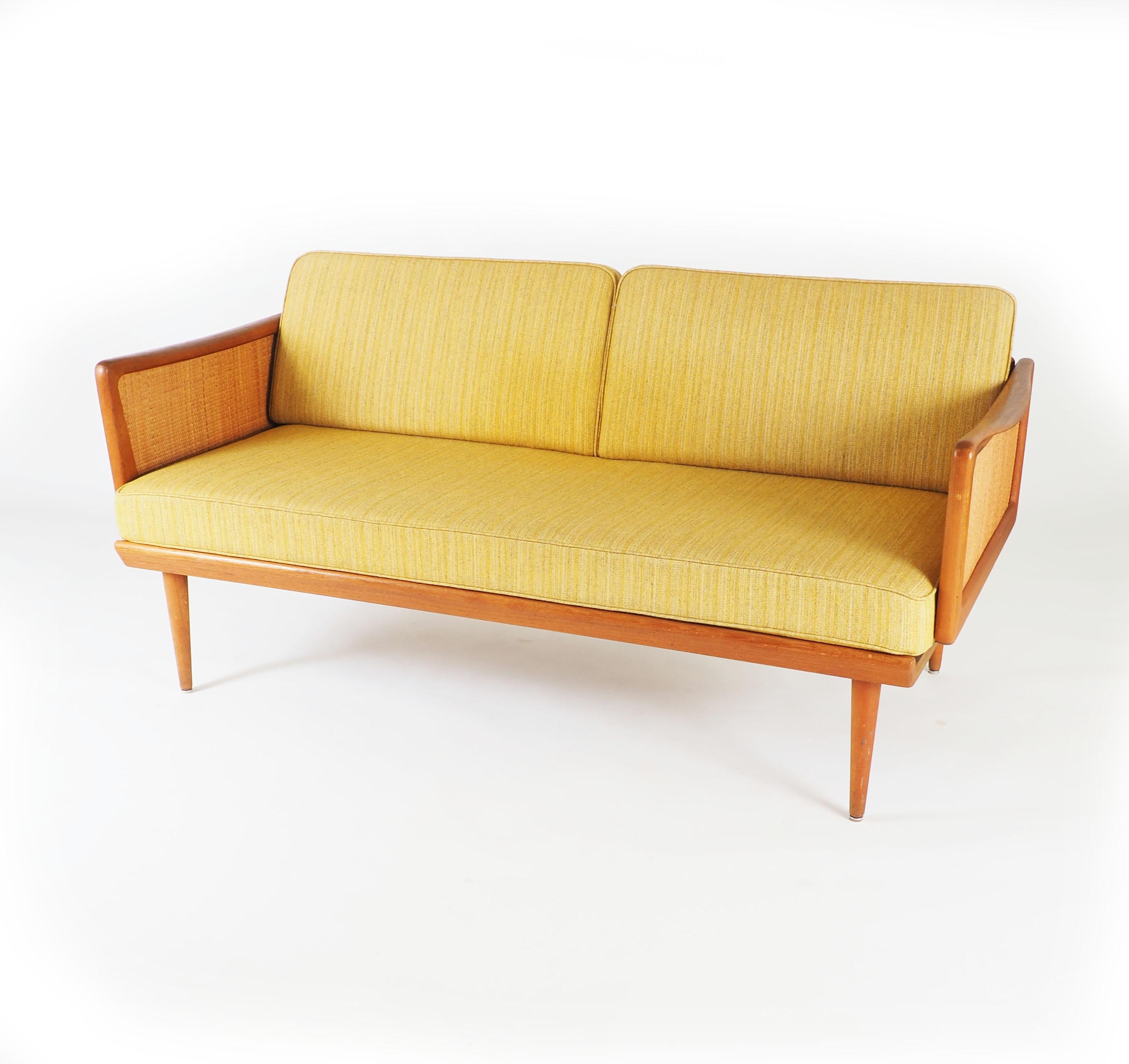 Convertible sofa and daybed by Peter Hvidt and Orla Mølgaard-Nielsen. Made by France and Daverkosen, Denmark in teak and rattan. Model fd451. The side panels can be lowered for a longer resting space.