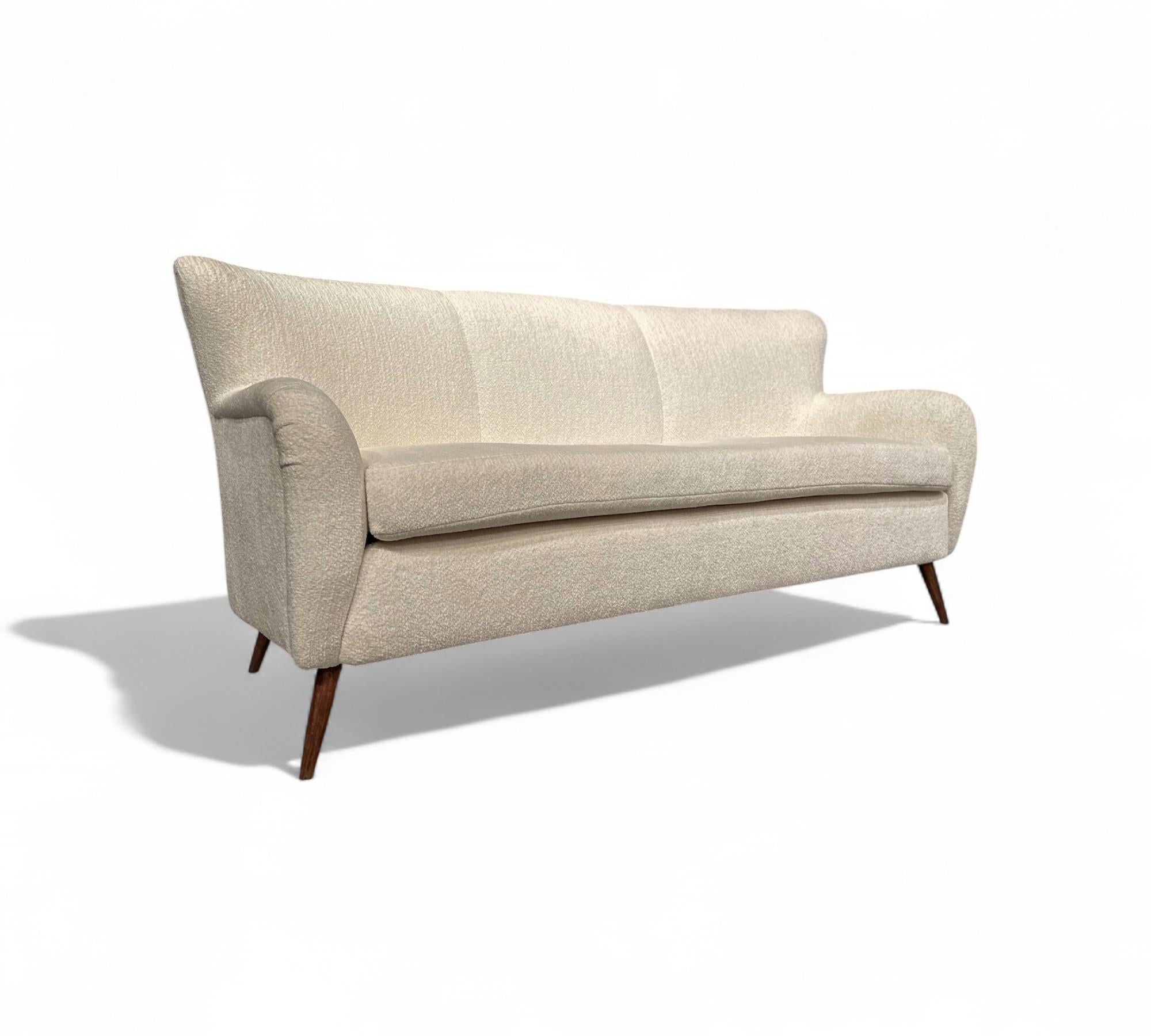 This sofa, made by Forma in the 1960s, retains its original structure and has been reupholstered in a White boucle. The legs, crafted from Caviuna wood, add a touch of elegance and durability. The combination of the vibrant velvet and the sturdy