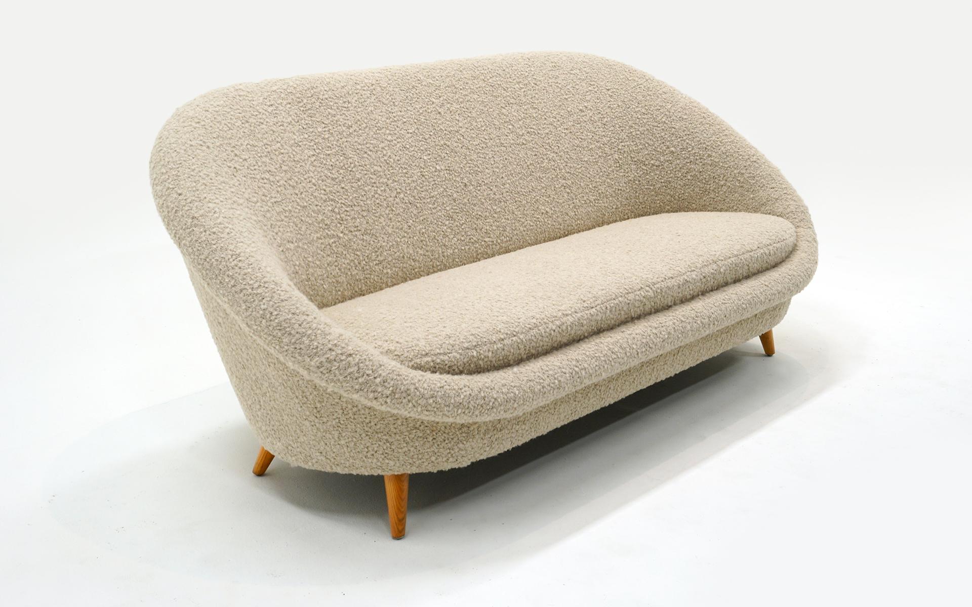 Sofa Settee attributed to Kurt Ostervig, Denmark, 1950s.  Expertly restored in an off white /beige thick boucle.  Oak angled legs.  High quality construction.  Comfortable and beautiful from every angle.  
