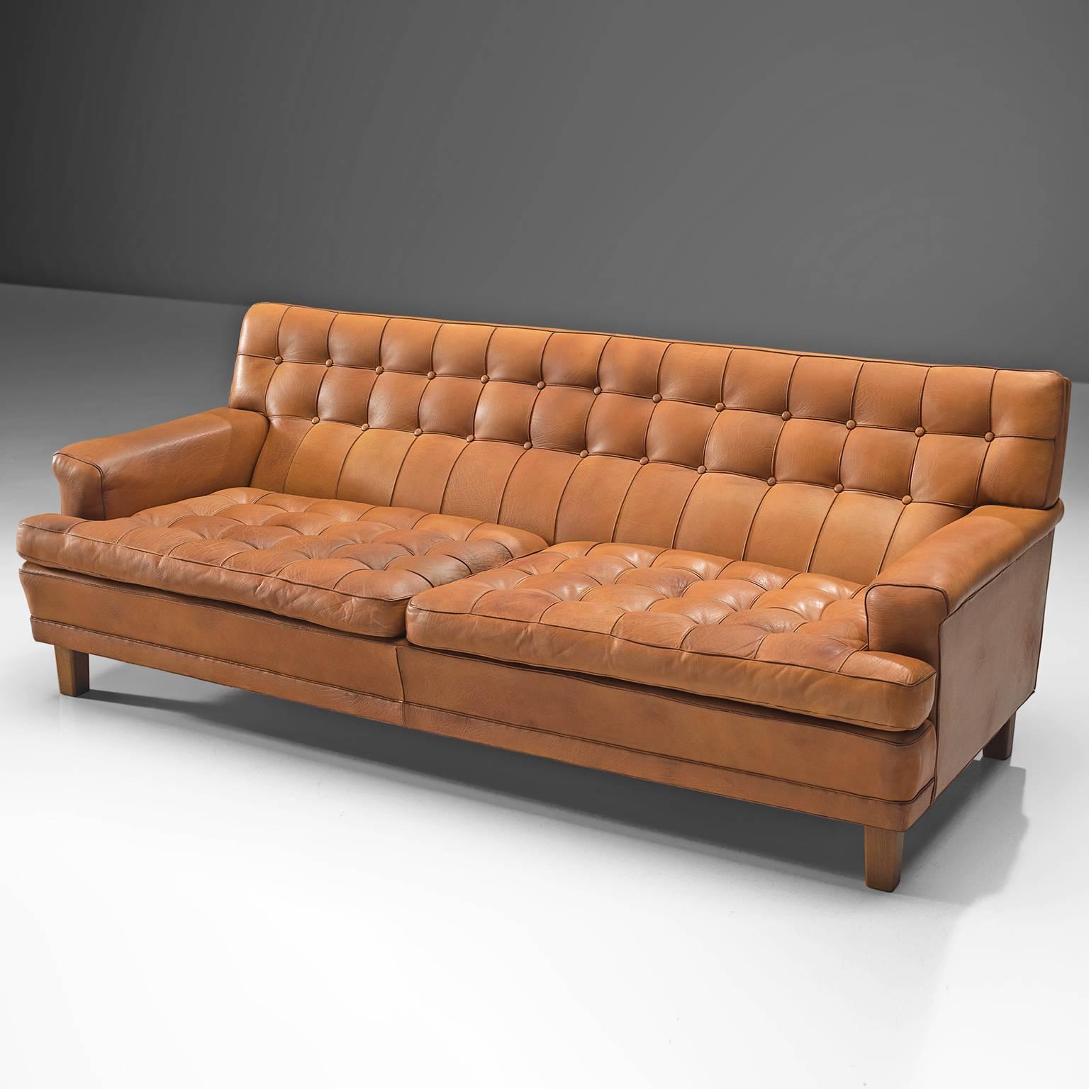 Arne Norell, sofa 'Merkur', cognac leather and wood, by Sweden, circa 1964. 

Three-seat sofa by Arne Norell. This sofa is refined, modern and with a robust touch. A true Swedish and Norell design. The sofa is made of cognac light brown leather