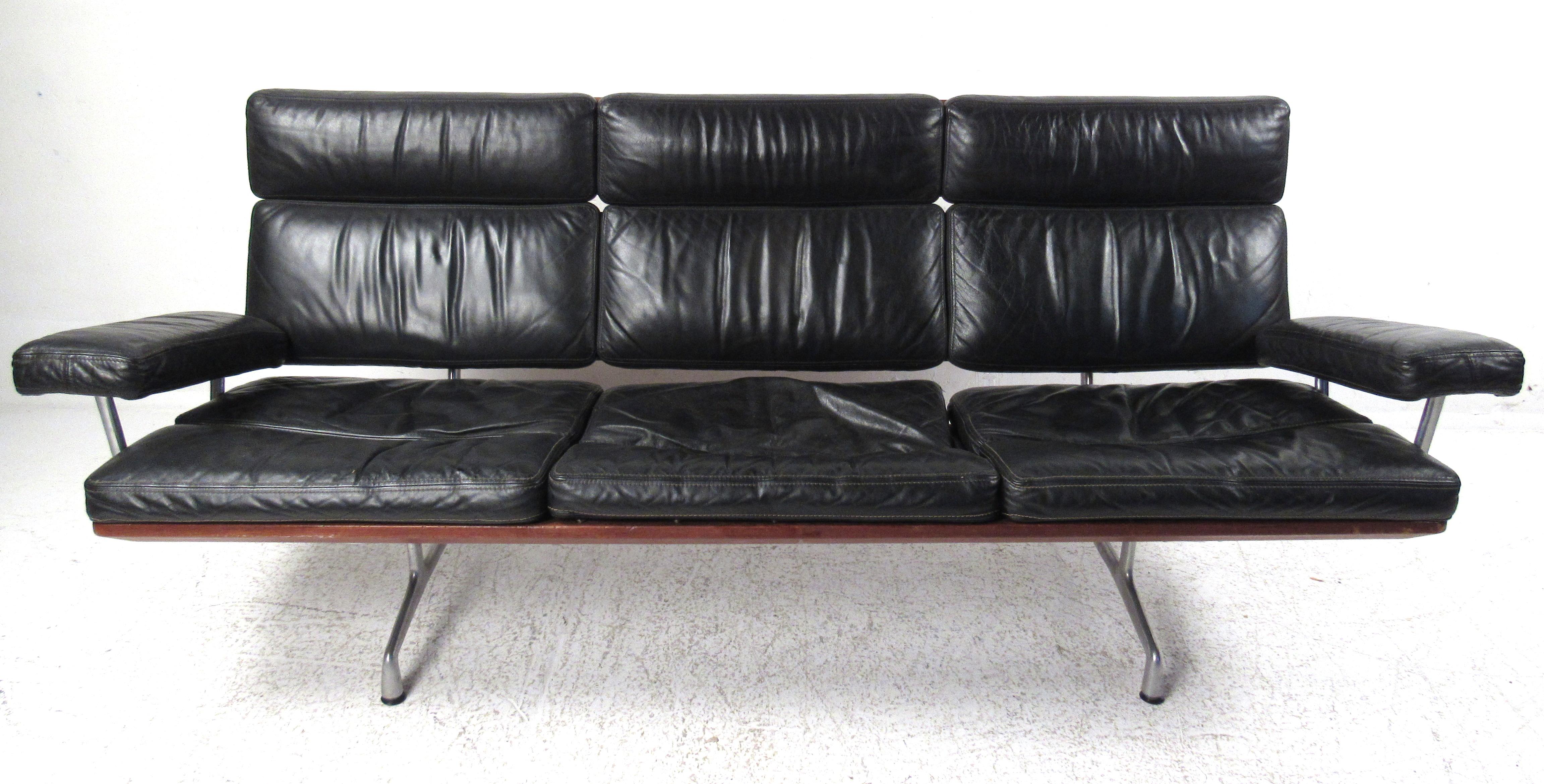 Beautiful three-seat sofa in black leather with teak and aluminum frame by Charles and Ray Eames. Conceived in 1967, it was later put into production in 1984 and was the last furniture design from the Eames office. Please confirm item location (NY