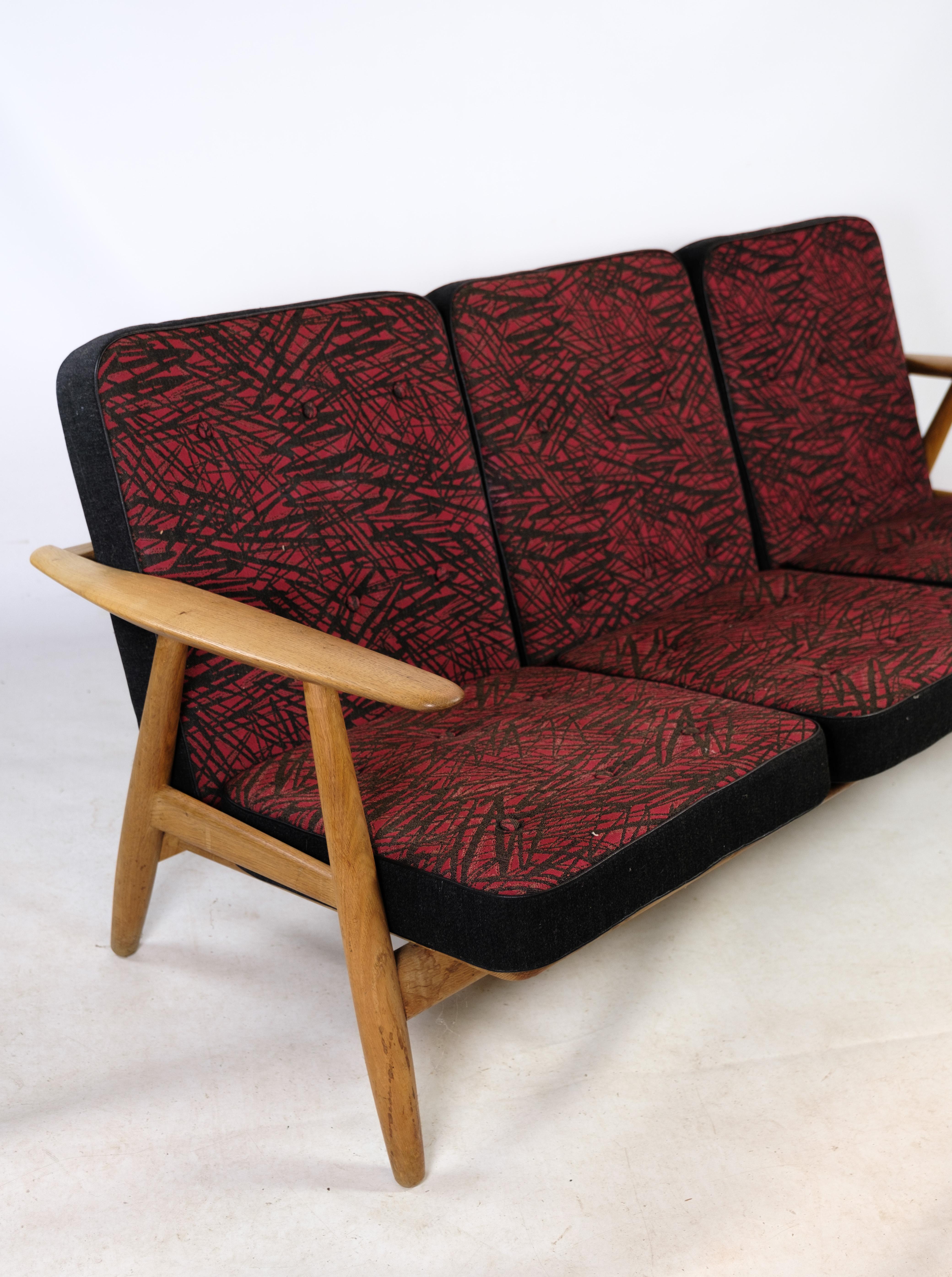 3-person sofa, Model GE 240/ 3, designed by Hans J. Wegner in oak with black and reddish decorated cushions from the 1960s.
Dimensions in cm: H:70 W:175 D:55.