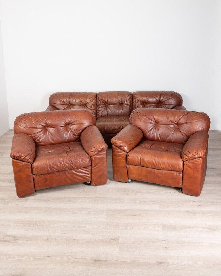 Set consisting of a three-seater sofa and a pair of armchairs, equipped with wheels, brown leather upholstery, Sormani design, 1980s.

Conditions: In excellent condition, they may show slight signs of wear due to time.

Dimensions: Sofa
