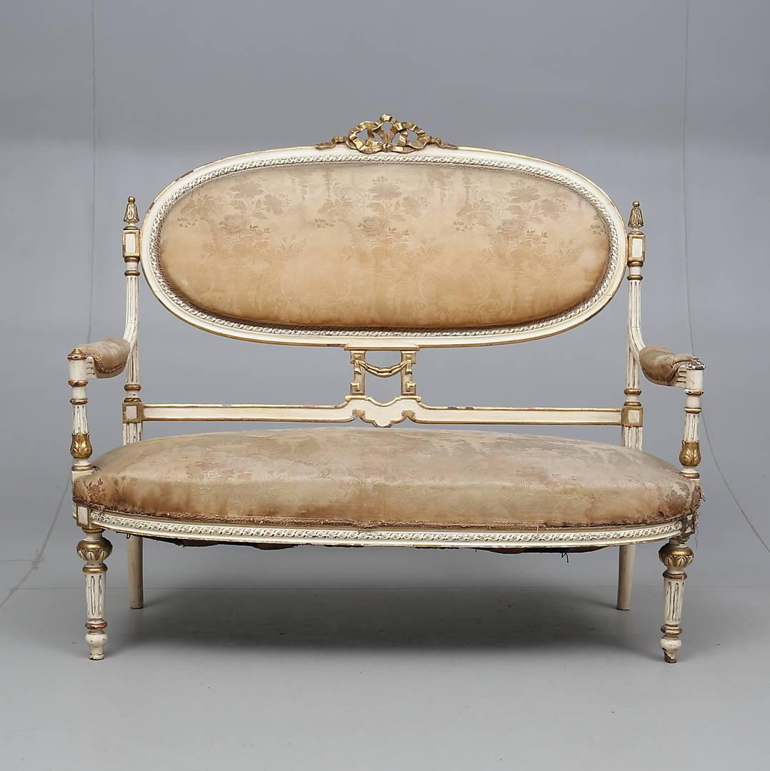 Sofa, Gustavian style, 1800-1810
Gilded and tanned. Carved decor eg blades. Crowned by ribbon bow. Fixed back upholstered and seat. Measures: Length about 131 cm.
Hard wear. Scratches and stains. Dry cracks. Injuries and out. Stains. Color