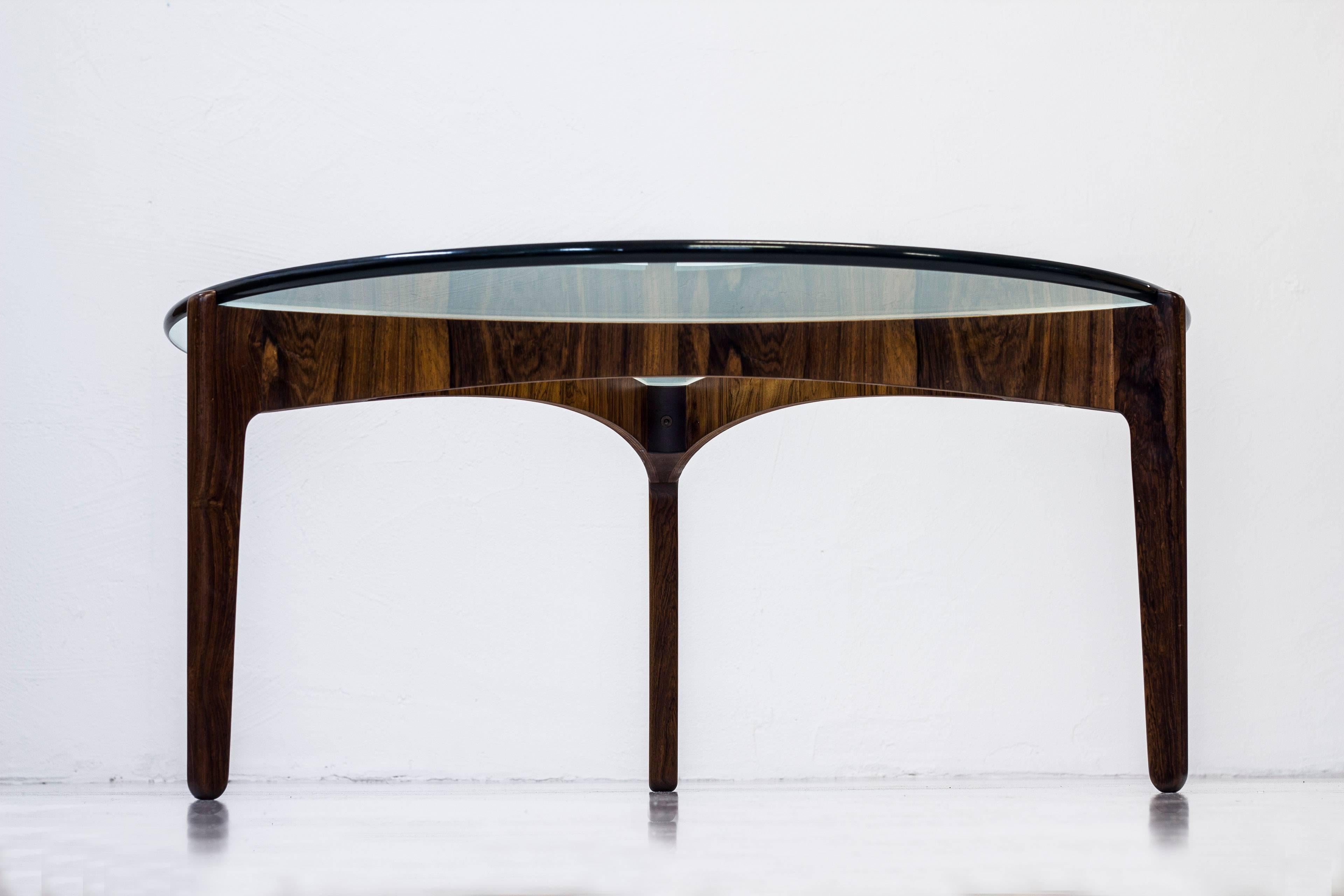 Sofa table designed by Svend Ellekaer. Produced in Denmark by Christian Linneberg furniture factory during the 1960s. Made from solid and bentwood palisander. Original, thick clear glass table top. Excellent condition with very few signs of wear and