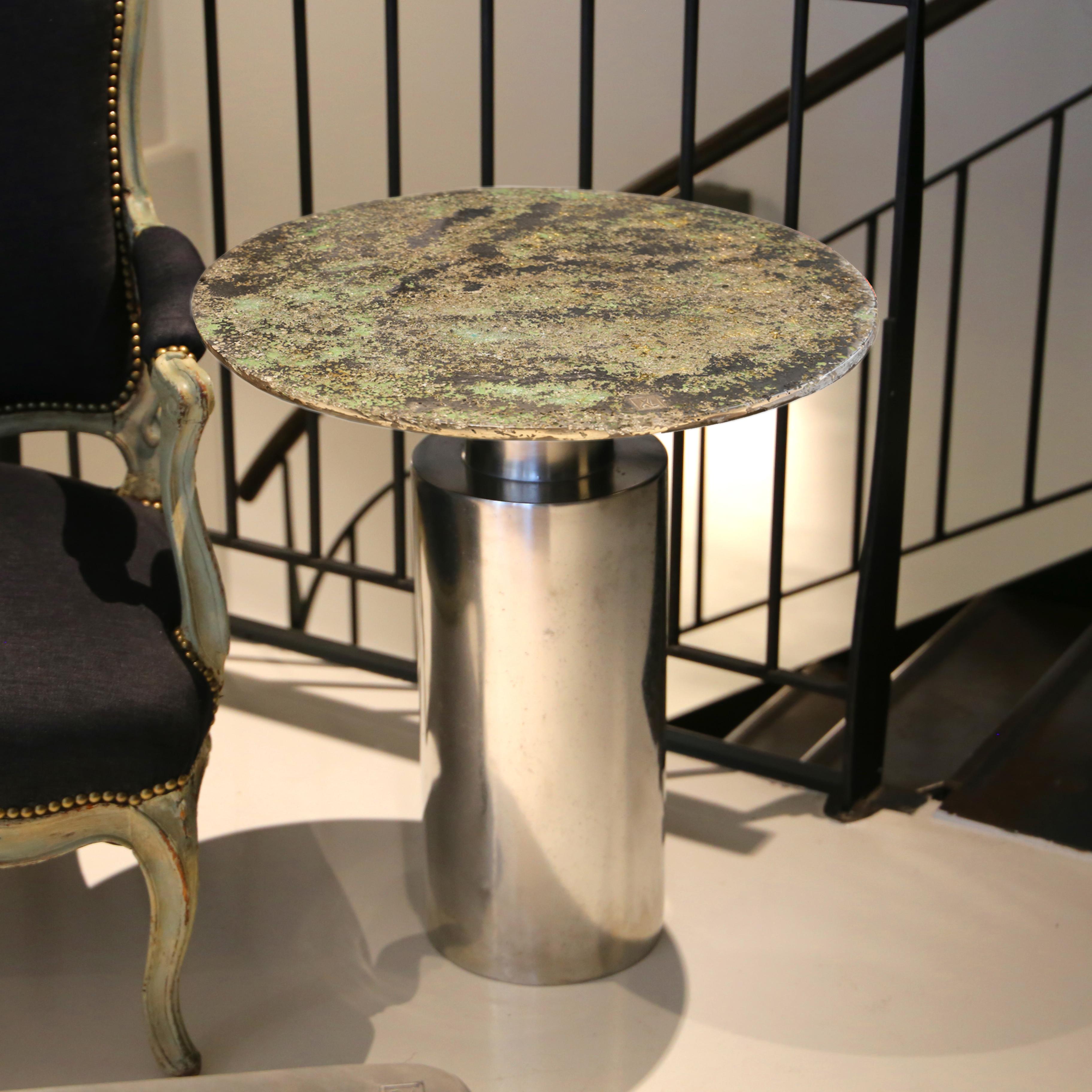 Cette table basse contemporaine est une pièce unique, créée par Xavier Lavergne et réalisée en étain fondu avec du verre de Murano de Venise, incrusté dans la résine et poli comme un marbre. La table est fabriquée à la main en France. Chaque pièce